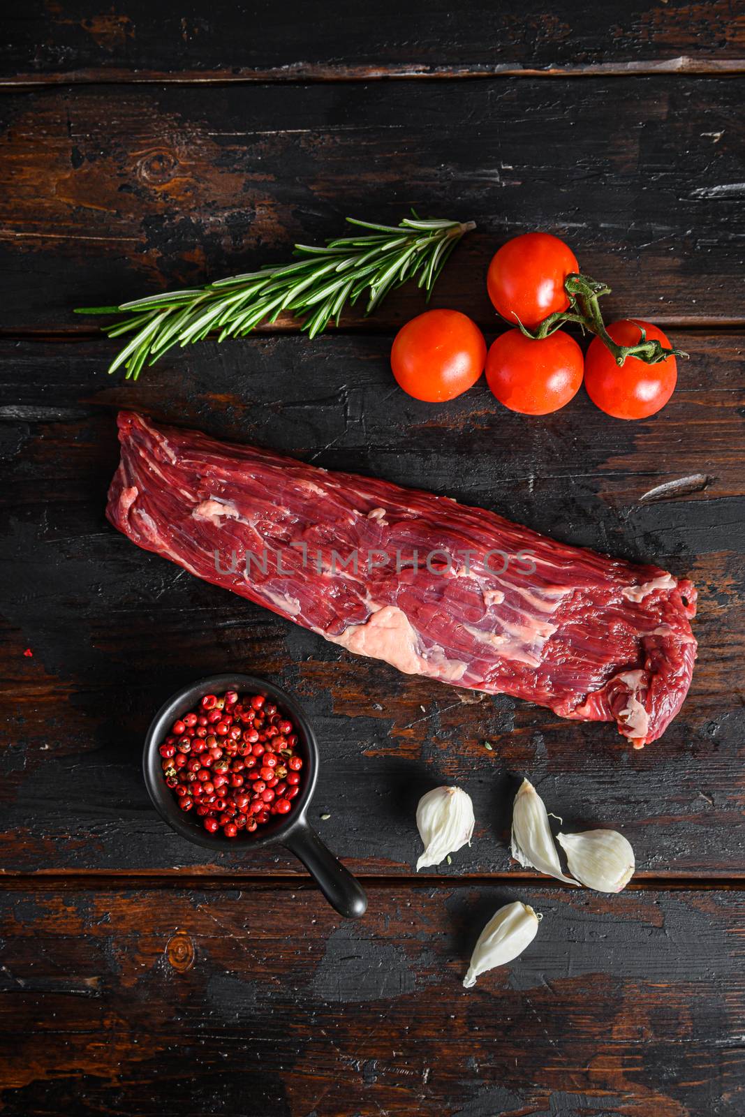 Organic Skirt Steak or Onglet cut, with rosemary over wood background Top view by Ilianesolenyi