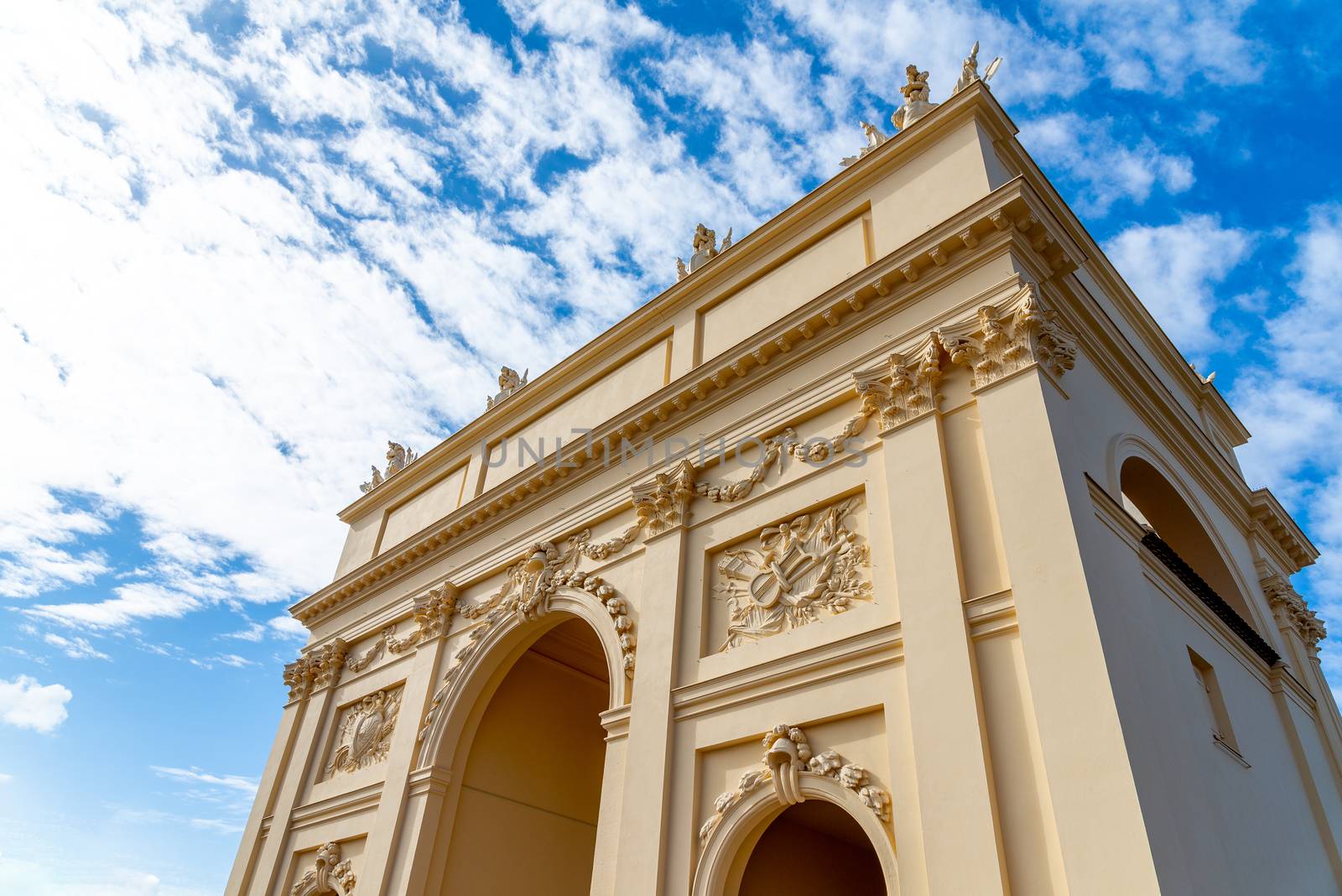 The Brandenburg Gate in Potsdam with many decorations in money photographed from below against the blue sky.