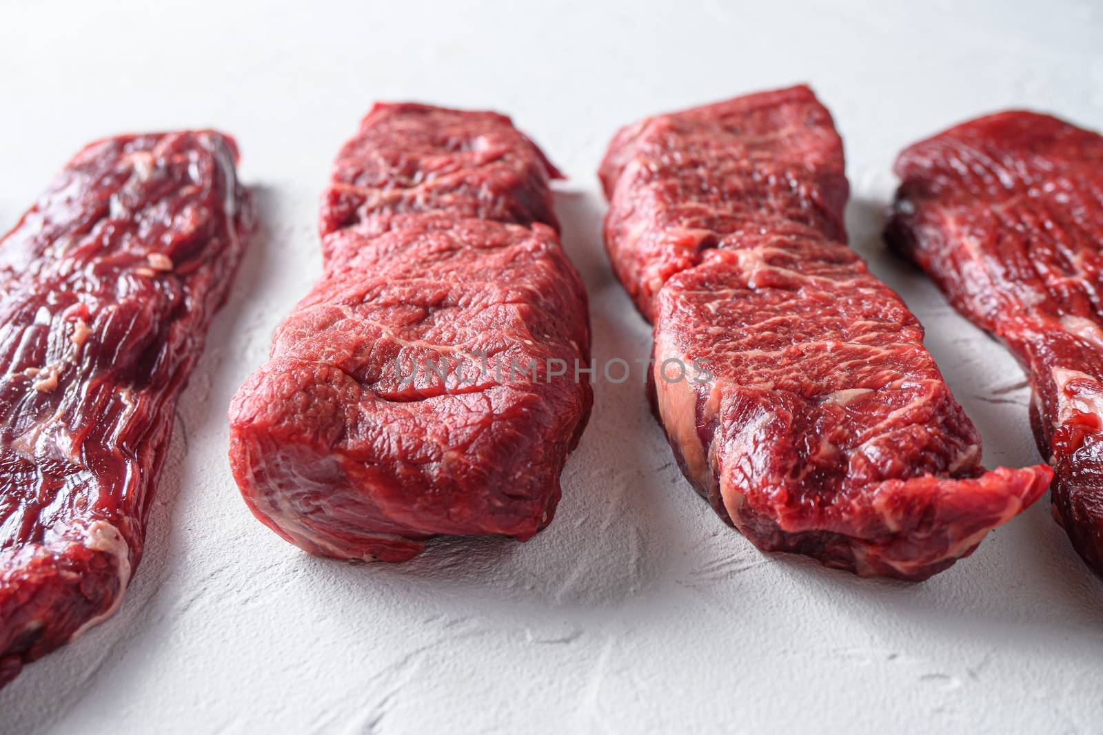 Set of denver, top blade, ranch steak , tri tip steak, machete, flank, bavette London broil marble beef on white background side view close up space view by Ilianesolenyi