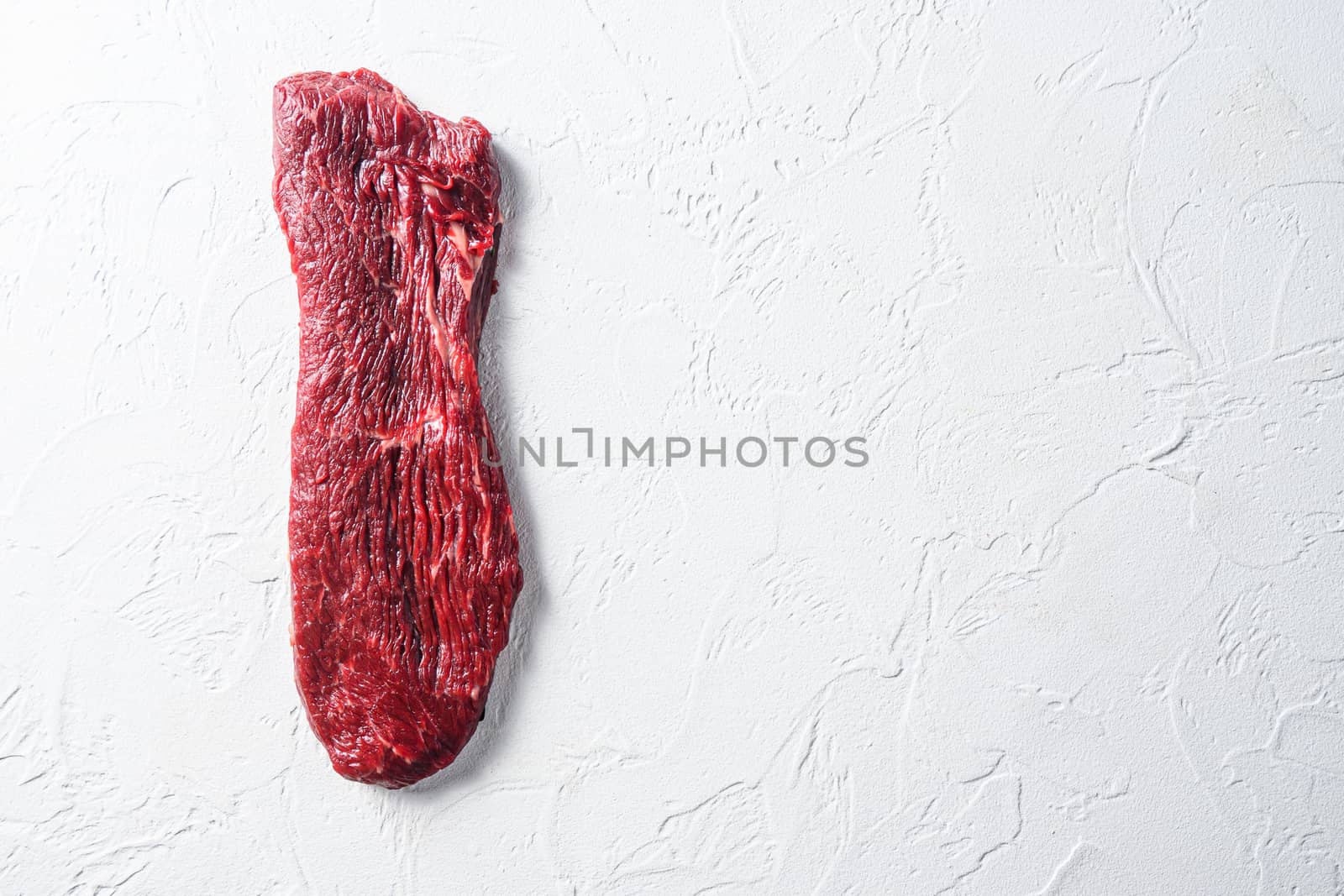 Raw tri tip, bottom sirloin steak on a white stone background top view space for text. by Ilianesolenyi