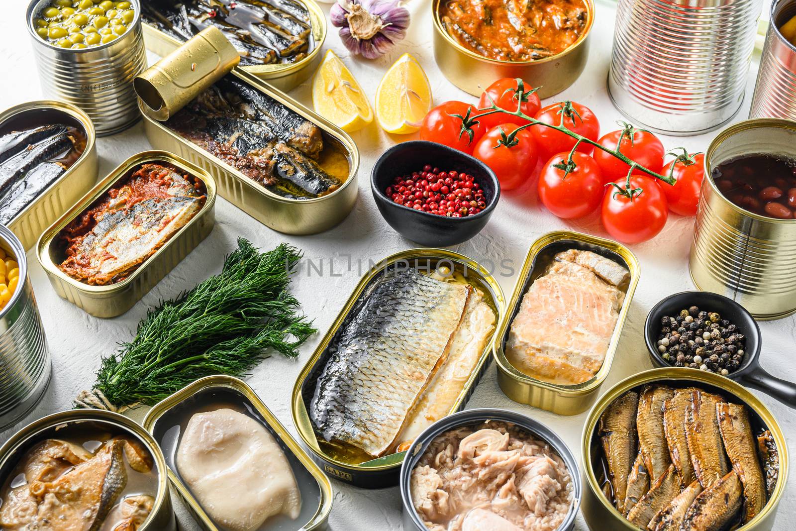 Different canned conserve products in tin cans. with fresh organic ingridients Saury, mackerel, sprats, sardines, pilchard, squid, tuna pinapple, corn, peas, mango , beans, over white textured background side view by Ilianesolenyi