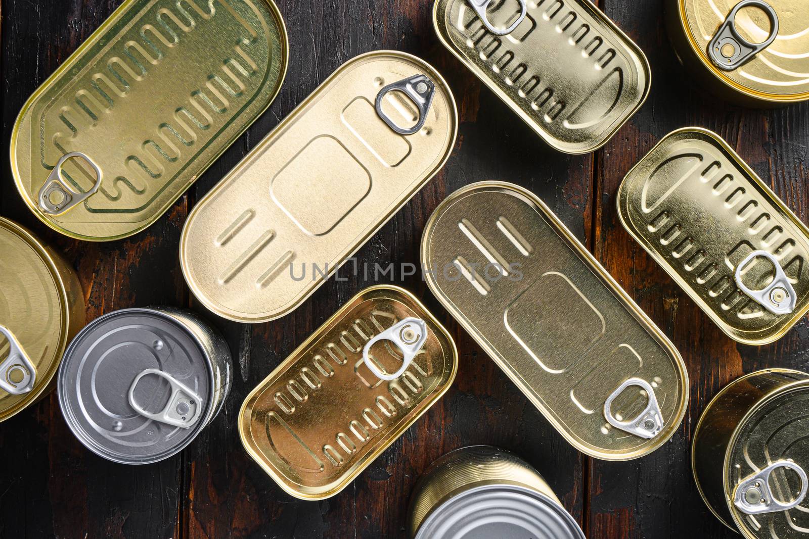 Various closed canned food, fish , fruits, vegetables, meat, soup different types of shapes top view on dark vintage table top view close up by Ilianesolenyi