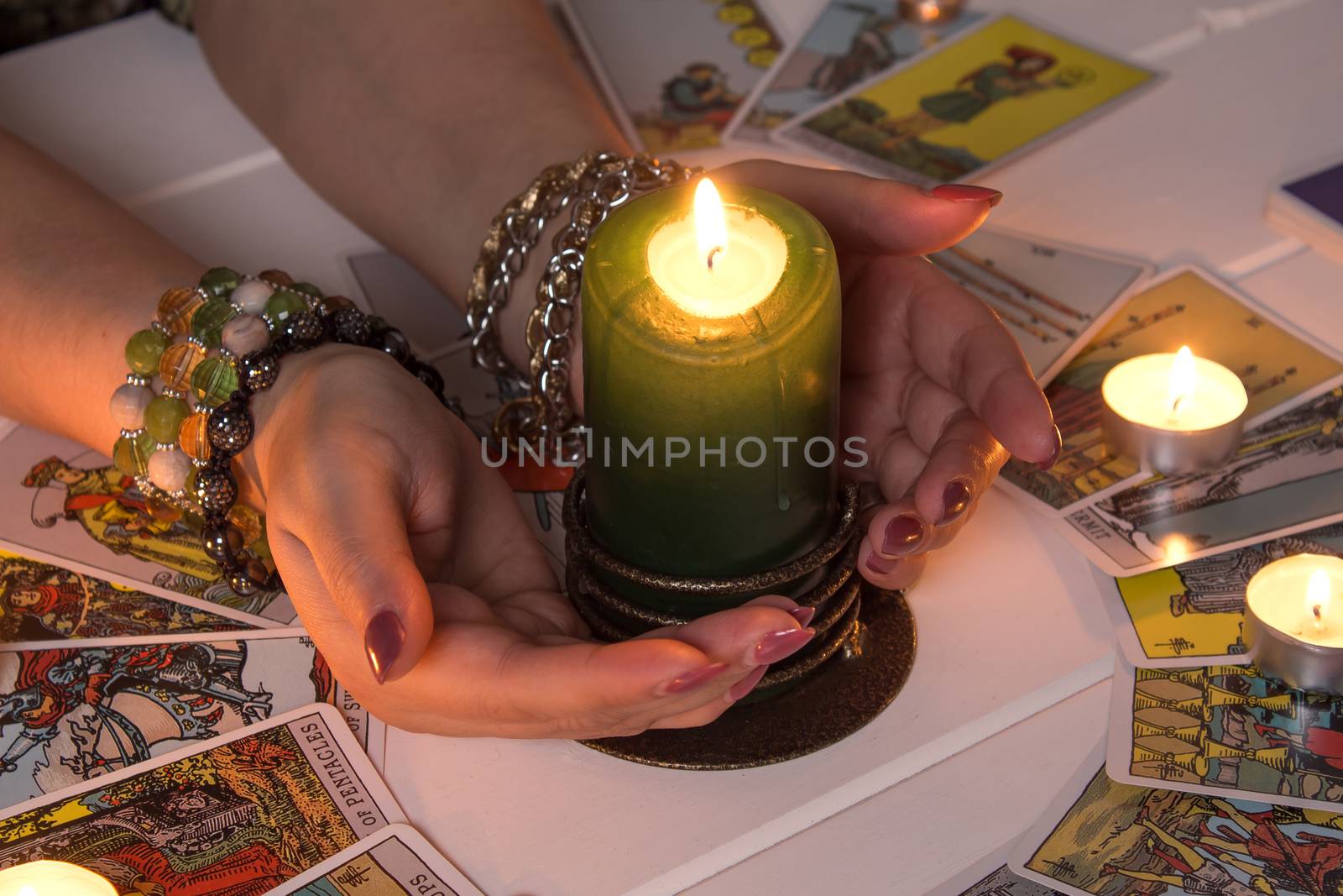 Bangkok,Thailand,March.15.20.Female hands hold a lighted candle in the dark at night. A fortune teller performs a magical. Ritual of enchantment and clairvoyance. Seance and prediction of the future