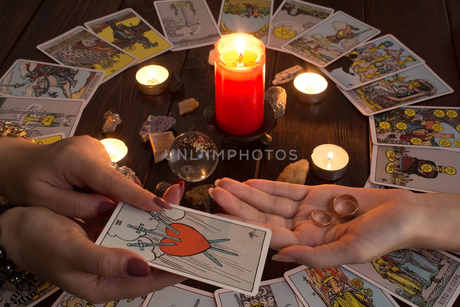 Bangkok,Thailand,March.15.20.The girl holds wedding rings on her hand with Tarot cards,crystals,a magic ball and a lighted candle.Fortune telling for love, the rite of love spell