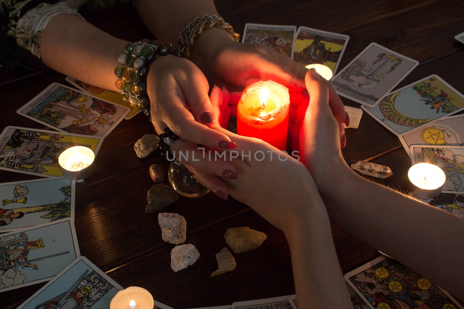 Bangkok,Thailand,March.15.20.Female hands hold a lighted candle in the dark at night. A fortune teller performs a magical. Ritual of enchantment and clairvoyance. Seance and prediction of the future