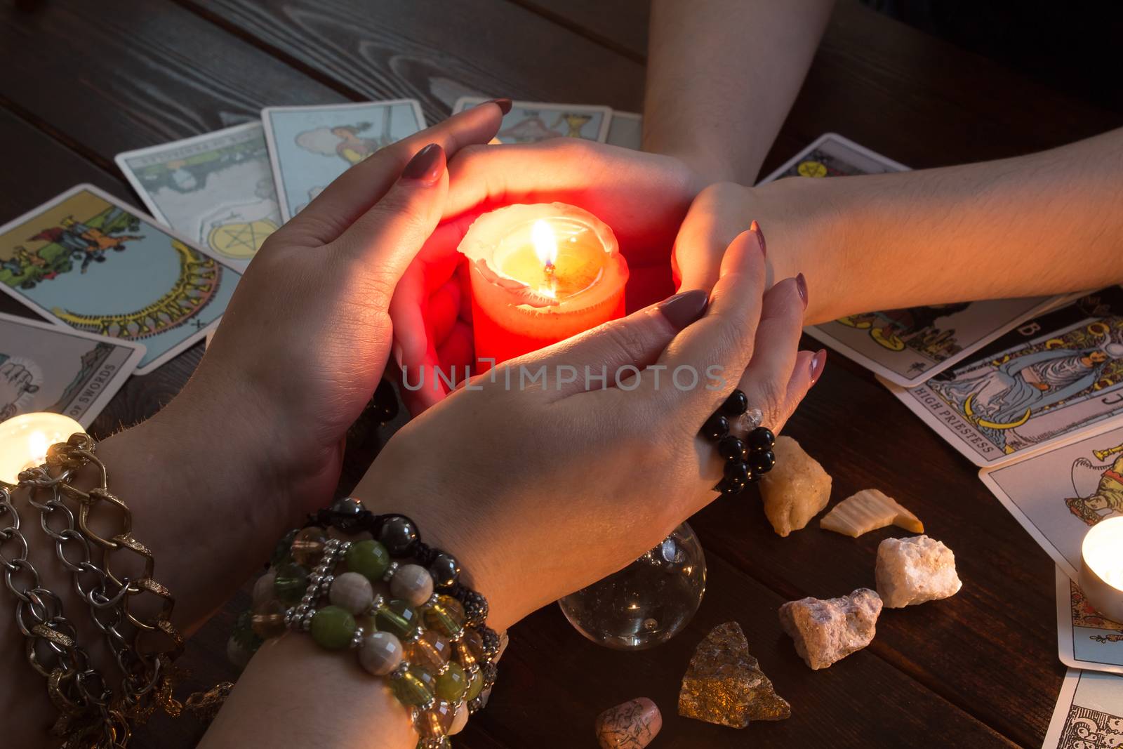 Bangkok,Thailand,March.15.20.Female hands hold a lighted candle in the dark at night. A fortune teller performs a magical. Ritual of enchantment and clairvoyance. Seance and prediction of the future