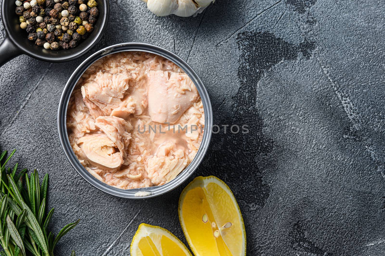 canned tuna open can with fresh herbs garlic and lemon ingredients for preservs top view close up space for text