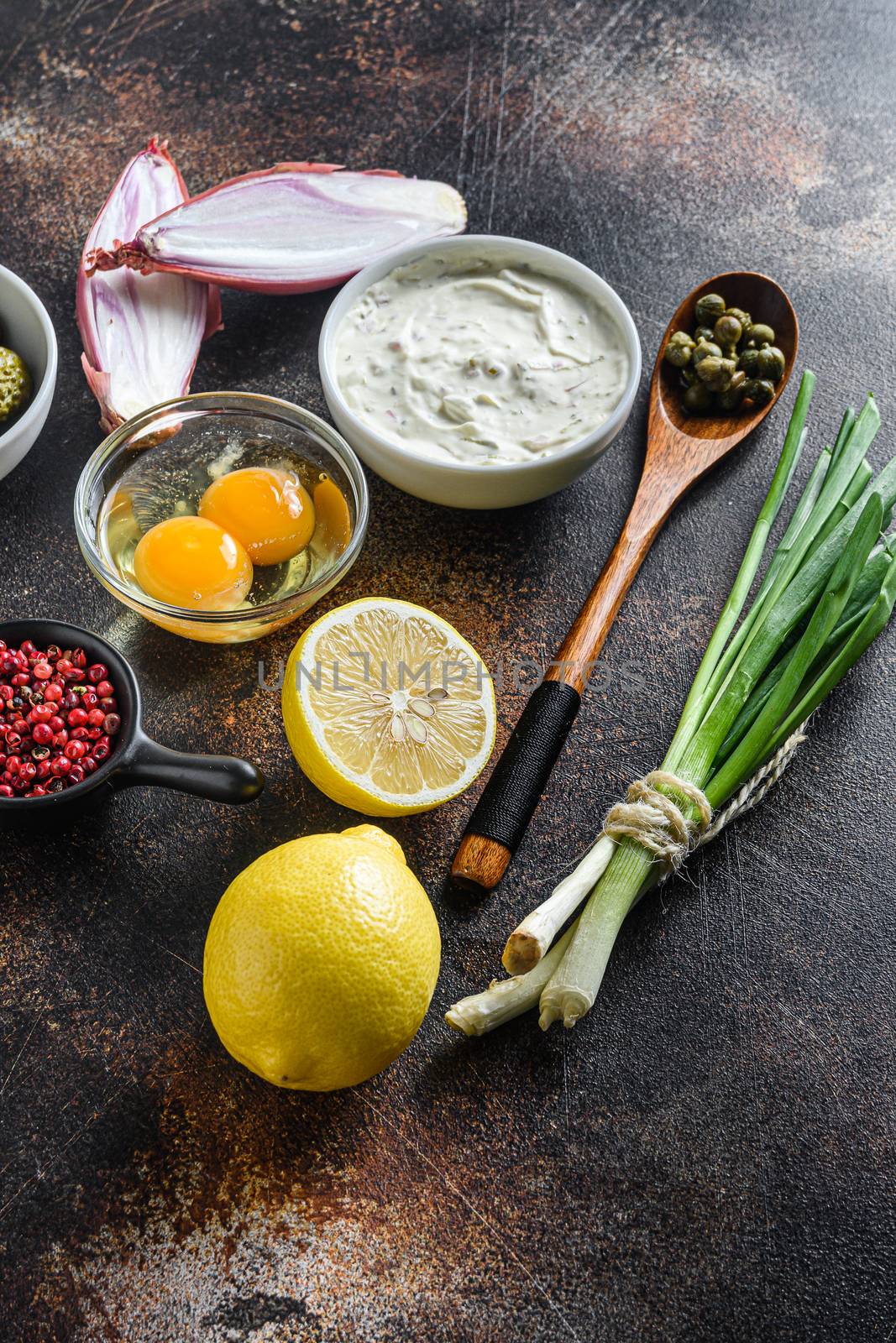 Sauce Tartar with organic capers pickles with green onions and herbs eggs lemon peppercorns over old metal textured dark background with rust overheade side view. by Ilianesolenyi