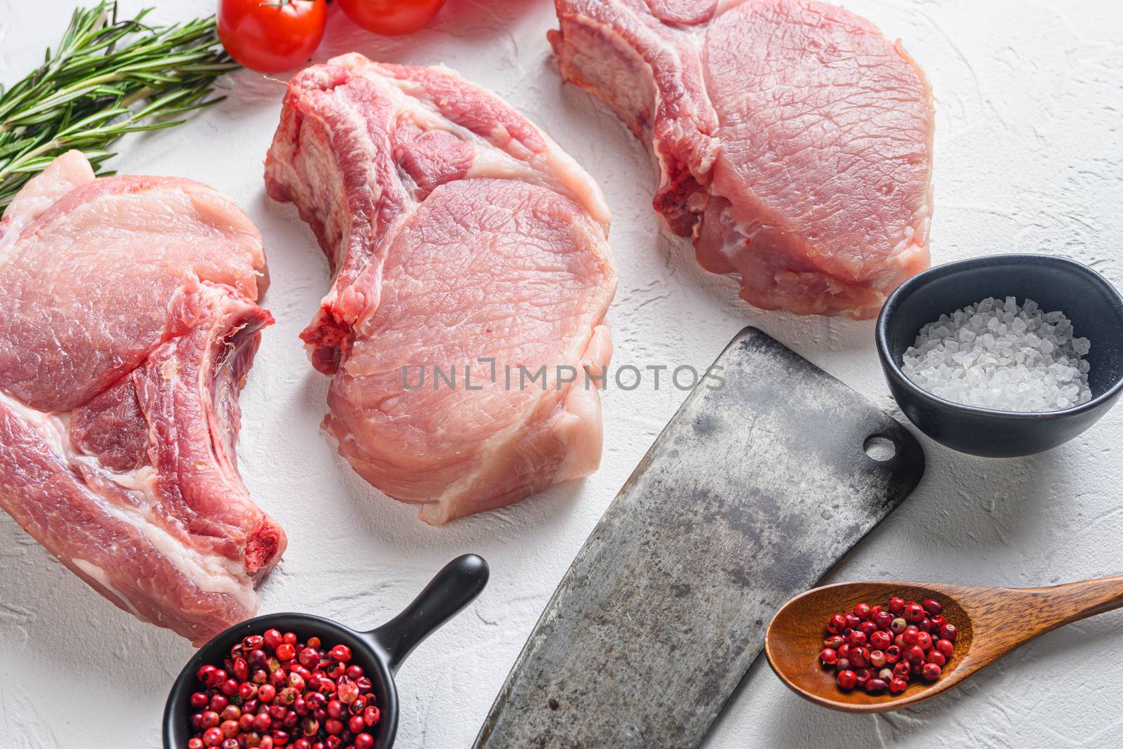 Set for bio grilling butcher american cleaver over organic bio Raw pork chops , baking or frying, textured white background. horizontal space for text. Top view by Ilianesolenyi