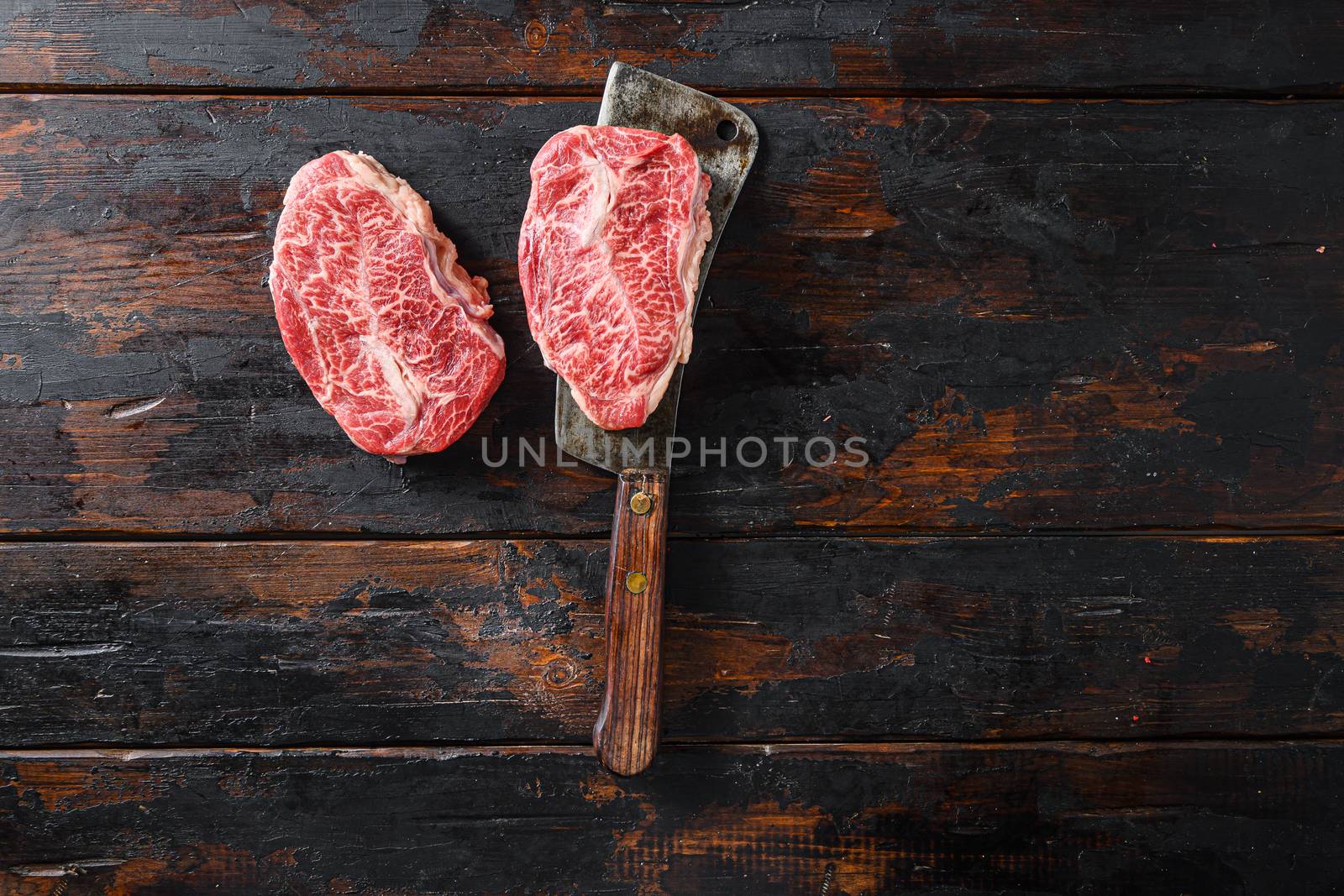 Flat iron steak, raw meat, marbled beef Top blade chuck cut on metal butcher cleaver knife top view space for text.