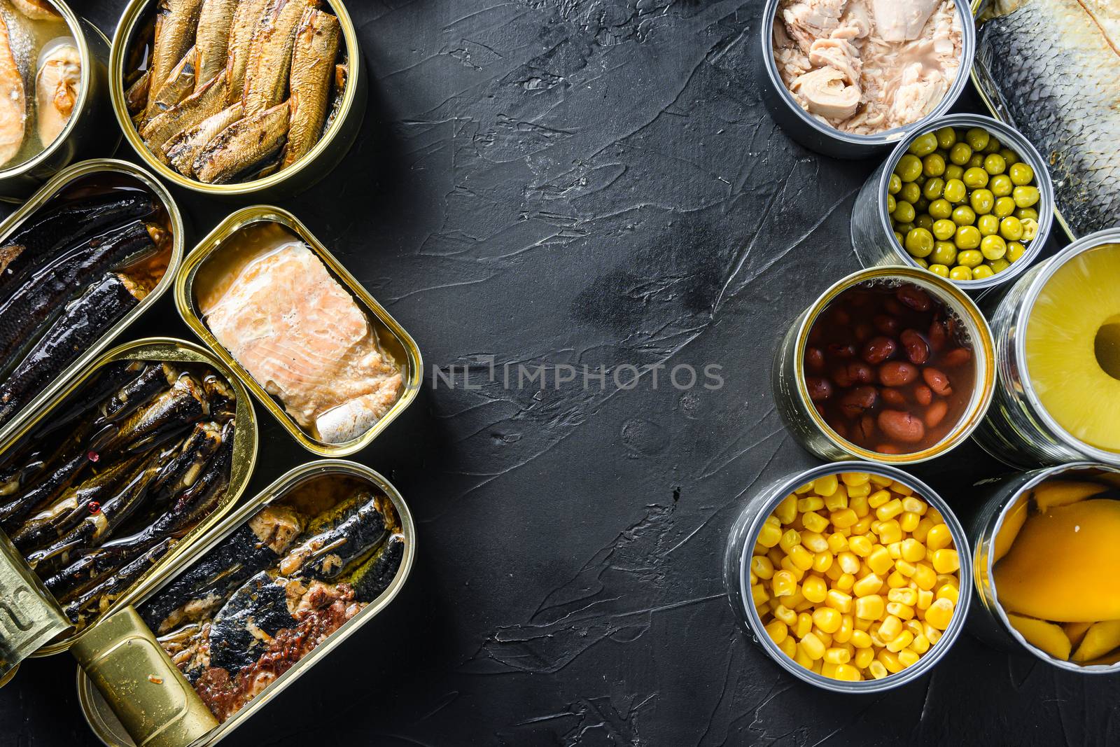Canned conserve products in tin cans. with fresh organic ingridients Saury, mackerel, sprats, sardines, pilchard, squid, tuna pinapple, corn, peas, mango , beans, over black stone textured background top view space for text side by side concept by Ilianesolenyi