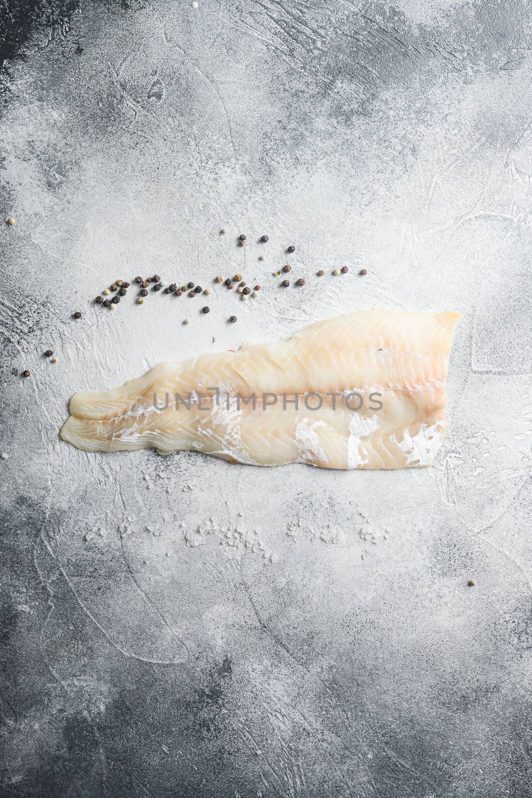 Cod fillets on a grey concrete background for the preparation of a healthy dish top view space for text by Ilianesolenyi