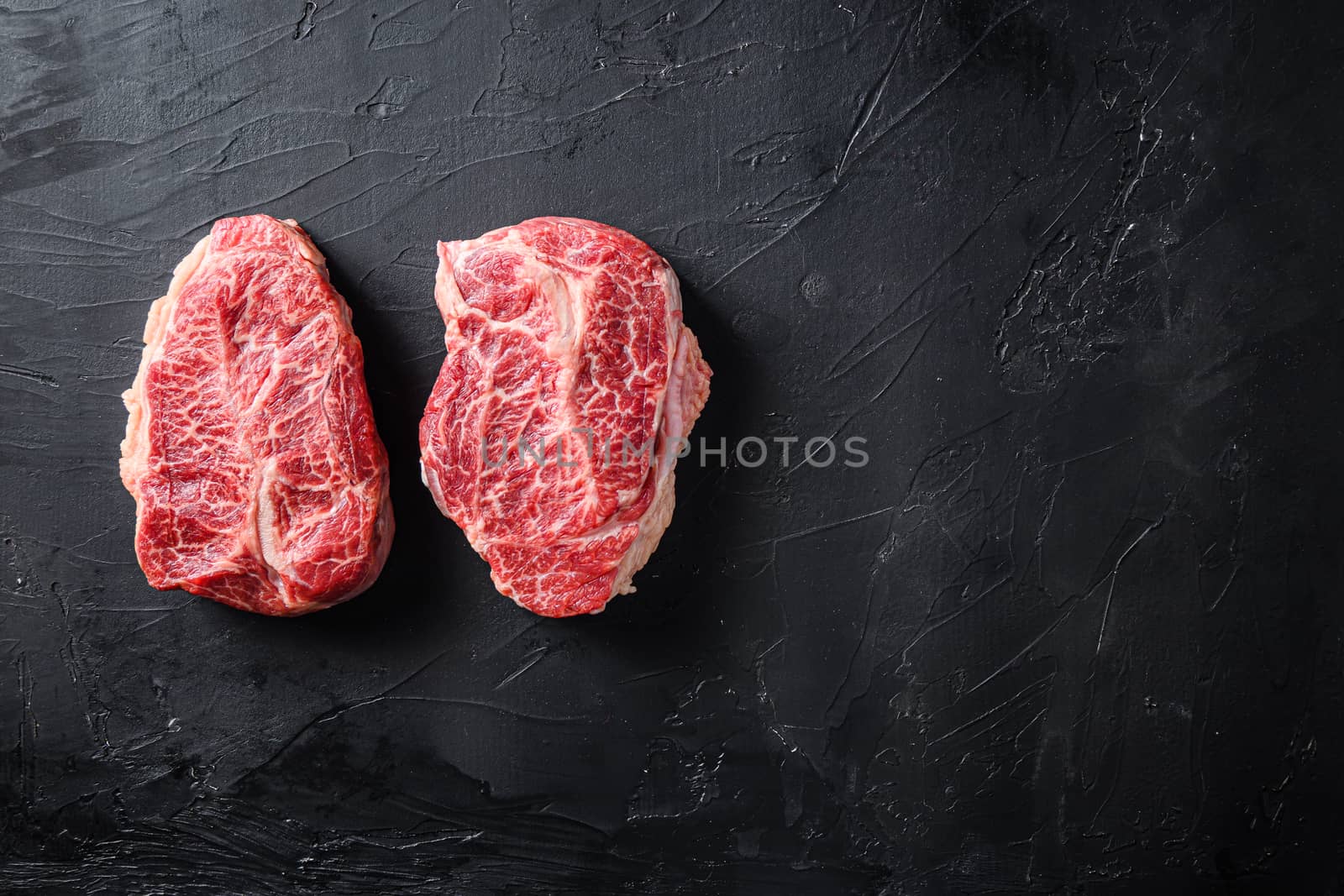 Raw organic meat Top Blade steaks or Australia wagyu oyster blade on black background top view space for text.