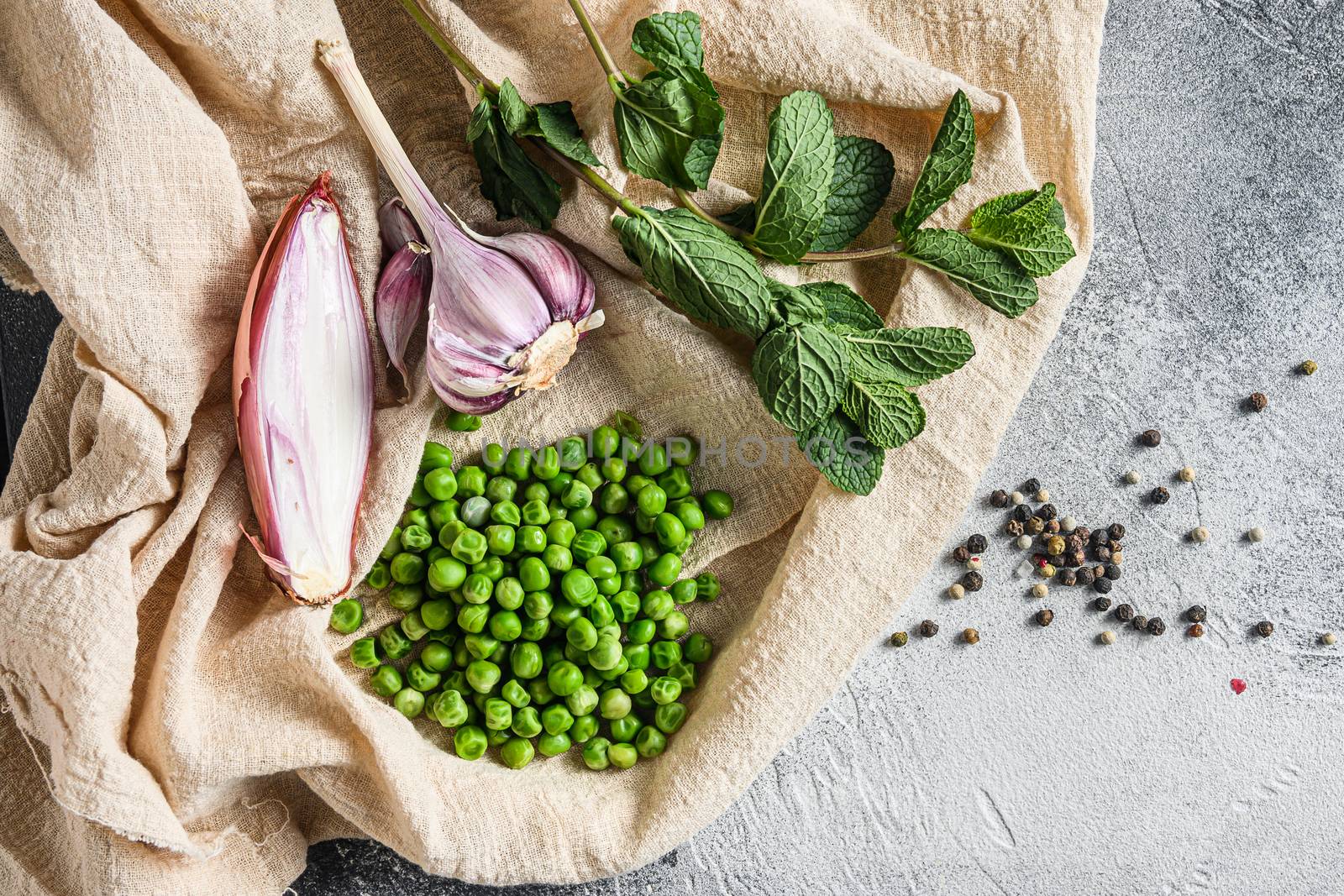 organic green peas for mushypeas and ingredients peas mint shallot pepper and salt keto food photo over grey stone background and cloth top view by Ilianesolenyi