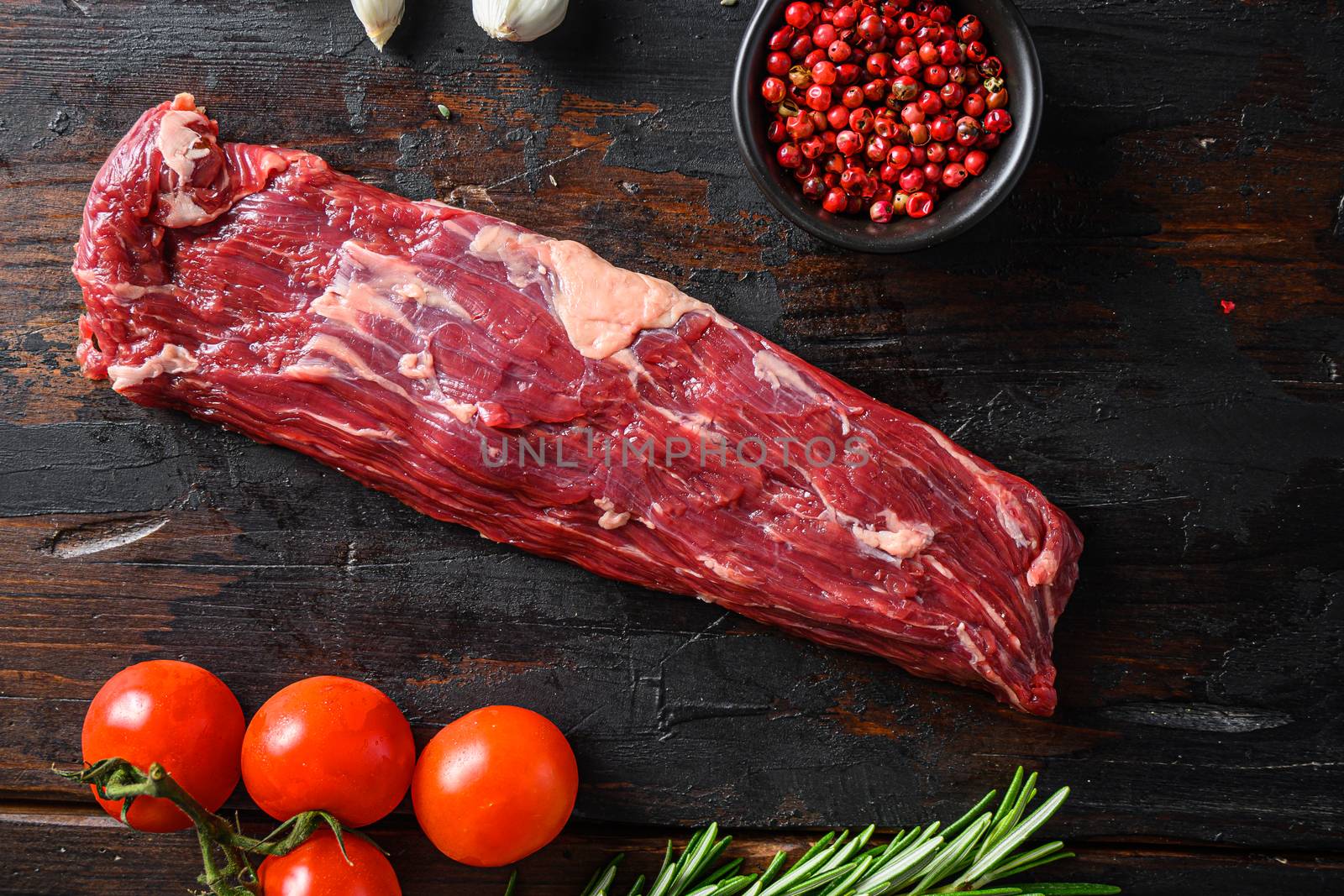 Machete steak raw alternative beef cut or hanging tende cut, with rosemary over wood background Top side view by Ilianesolenyi