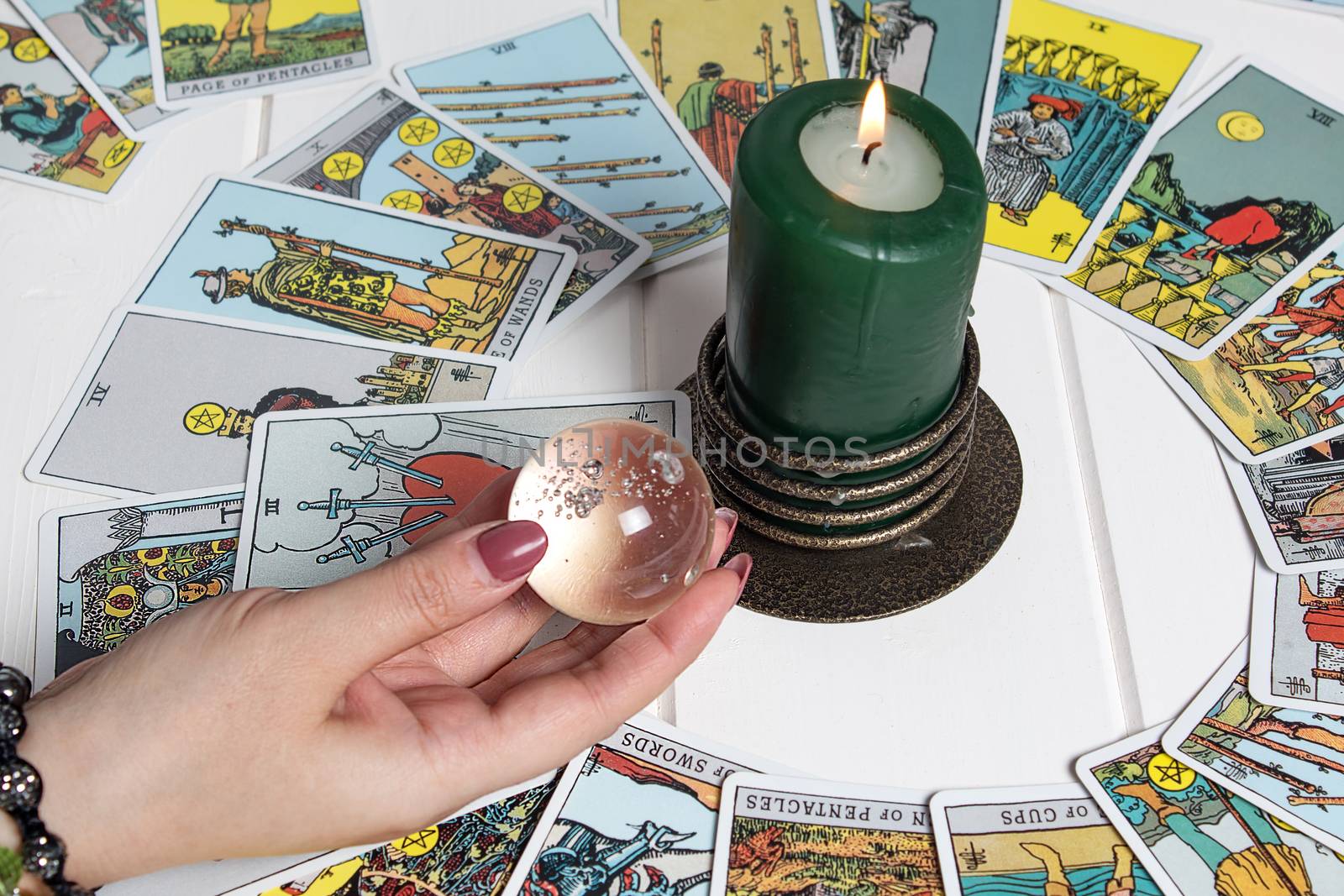 Bangkok,Thailand,March.15.20. A fortune teller holds a magic ball.On the table are fortune-telling cards and lighted candle.Magic sessions with clairvoyance cards.Reading maps by candlelight