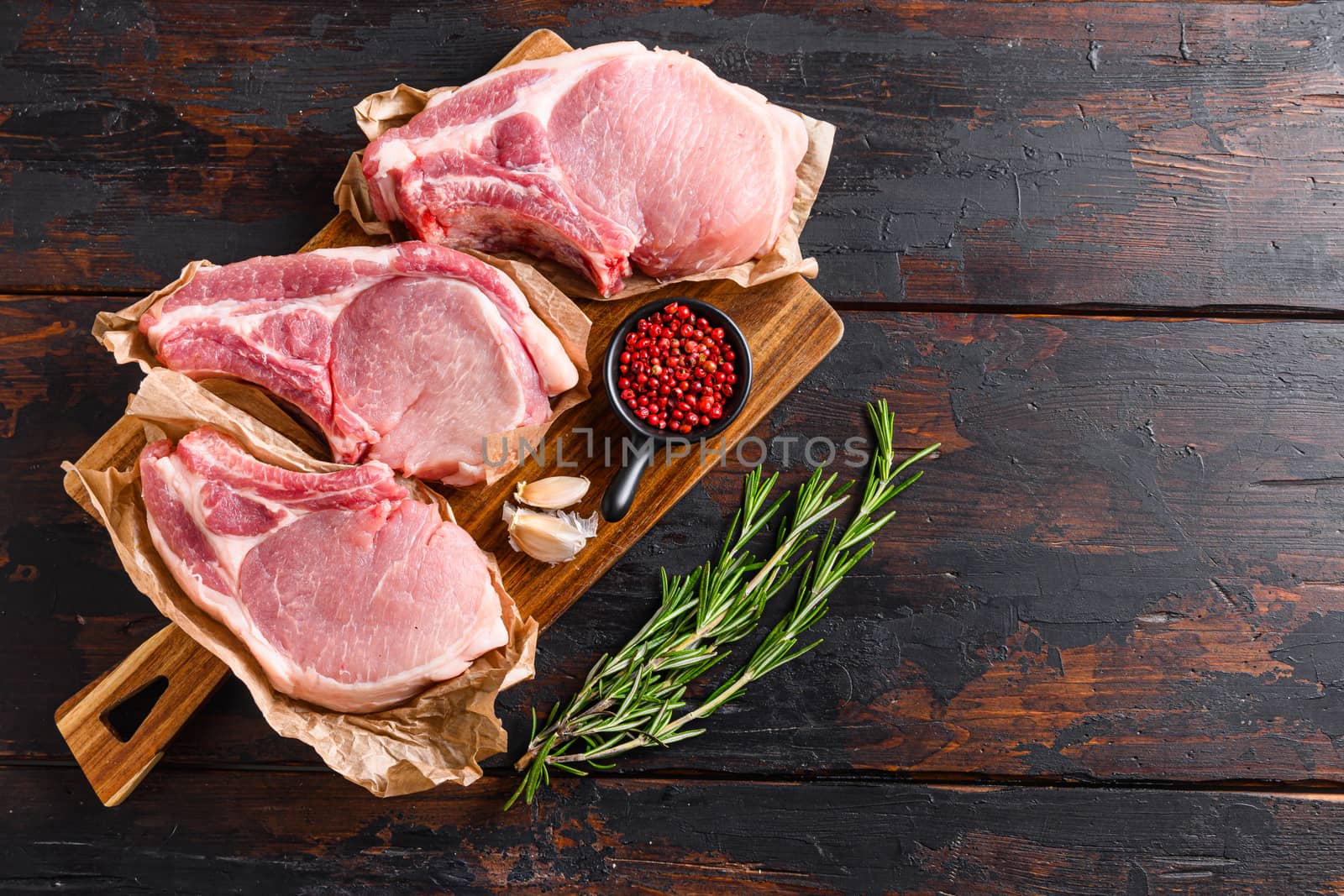 barbecue pork portion set over old rustic dark wood table with herbs and ingrefients top view space for text.