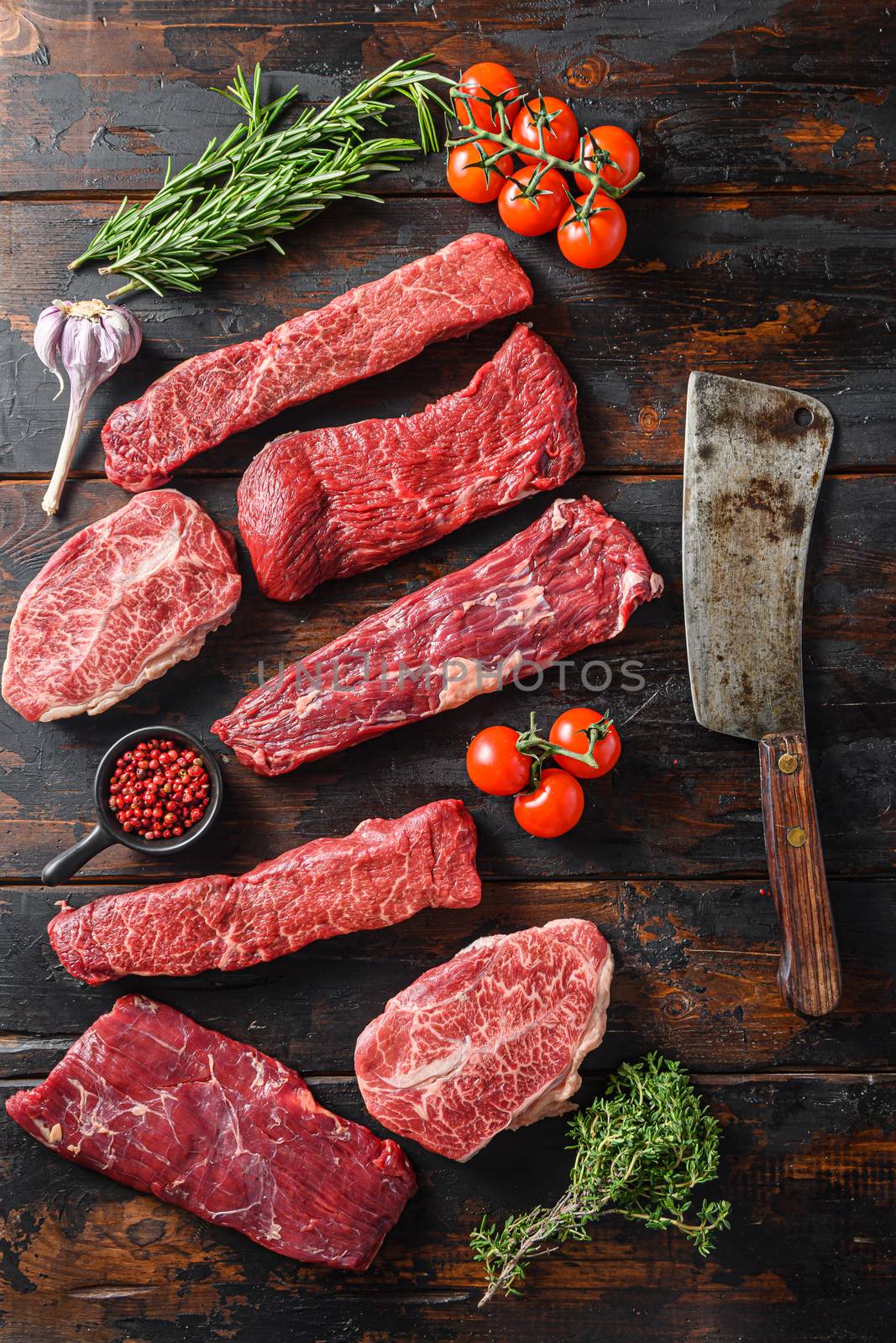 Set of flap flank Steak, machete steak or skirt cut, Top blade or flat iron beef and tri tip, triangle roast with denver cut with butcher cleaver top view over old butcher wood table by Ilianesolenyi