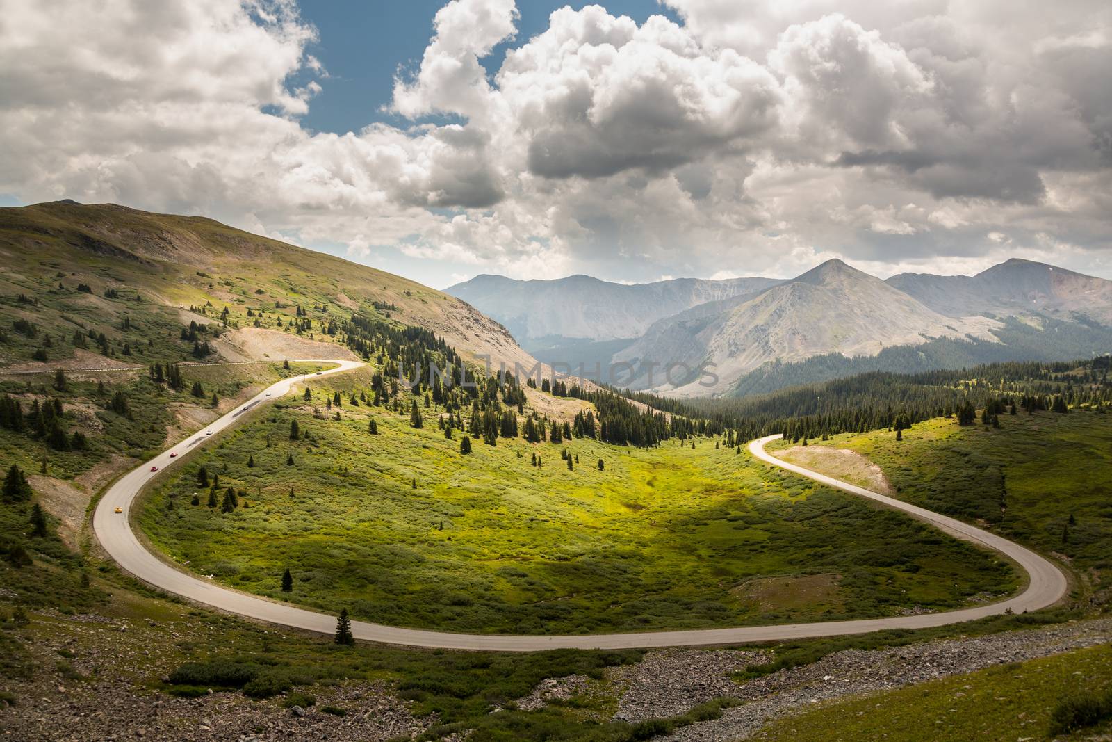 Large curving bend on road climbing to top of Cottonwood Pass in Colorado as sports cars race to summit