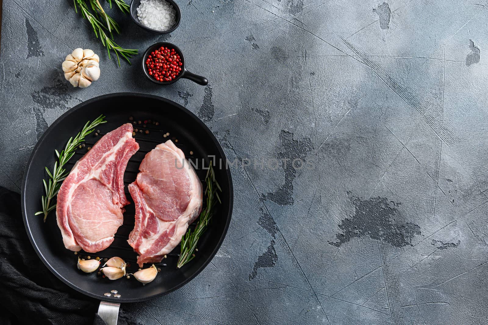 Pork steaks, fillets for grilling, baking in frying pan black skillet with herbs, spices top view flatlay space for text. by Ilianesolenyi