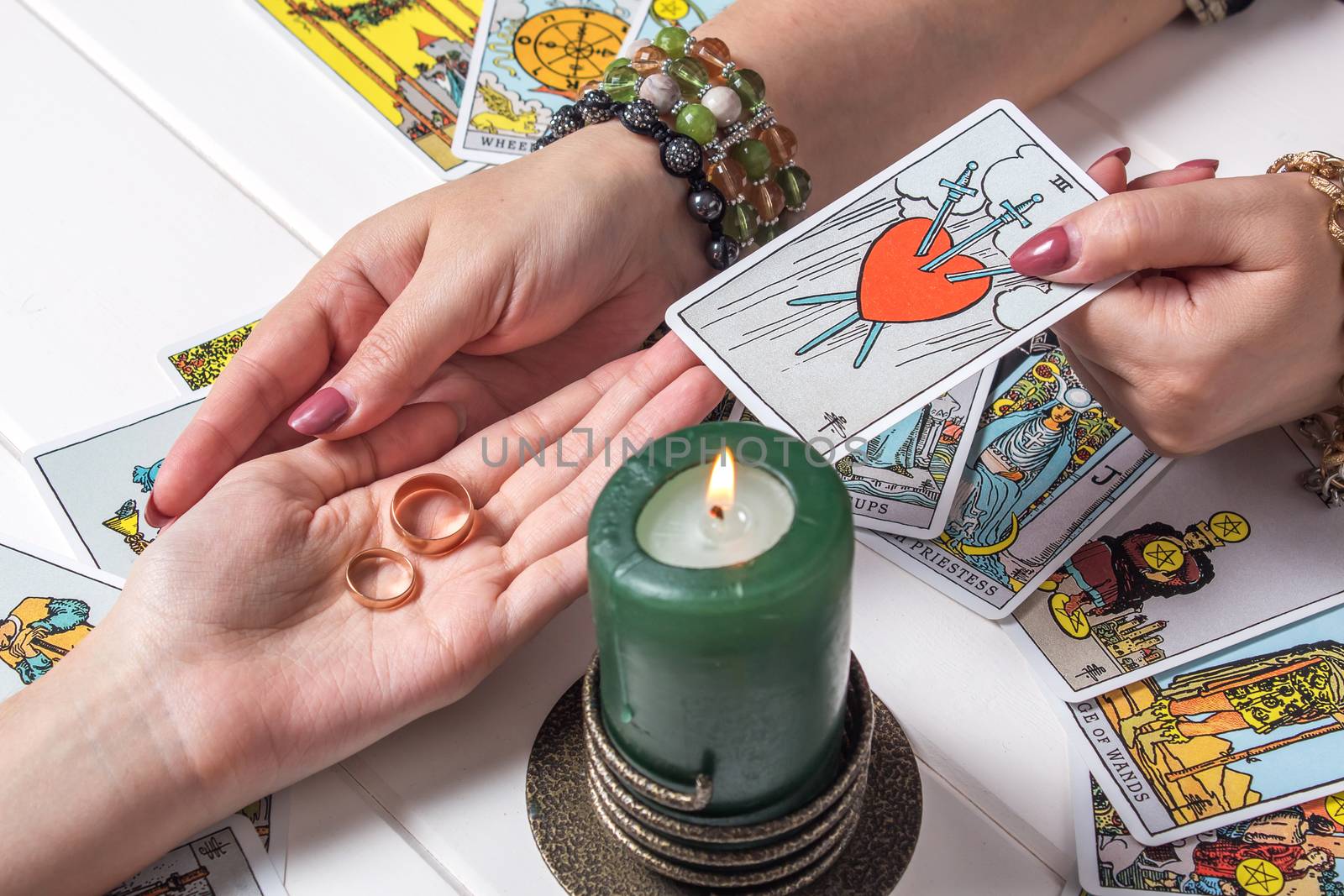 Bangkok,Thailand,March.15.20.Christmas fortune telling and fortune telling.A Gypsy woman guesses a love match using wedding rings and fortune-telling cards by candlelight.Spiritism and magic sessions