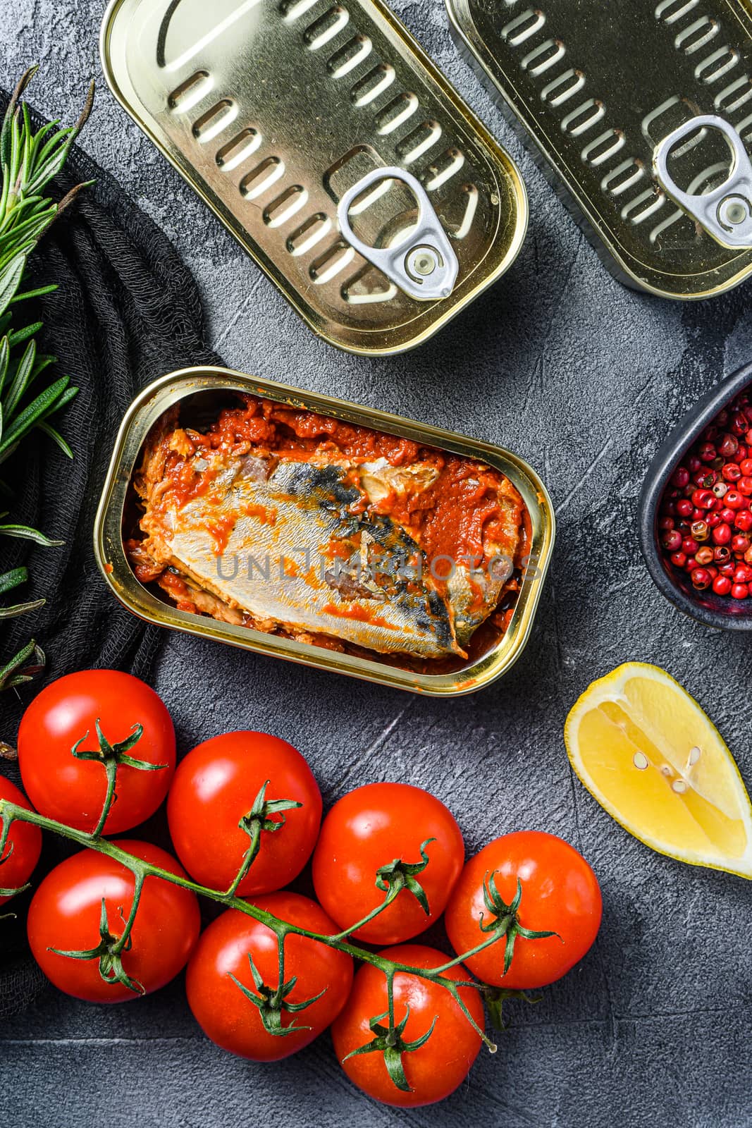 Tin can of mackerel, Scombridae opened and closed cans no label, with organic vegetables herbs and lemons top view vertical close up by Ilianesolenyi