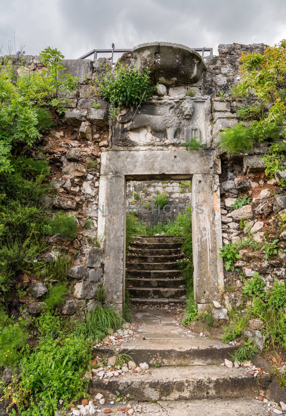 Stone entrance door with Venetian Lion of Kotor Fortress above the old town in Montenegro