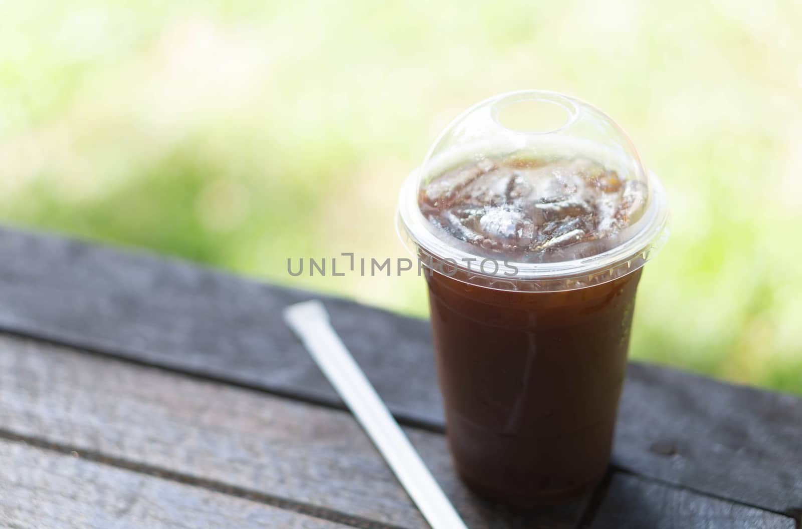 Close up glass of ice americano coffee on wood table, selective focus