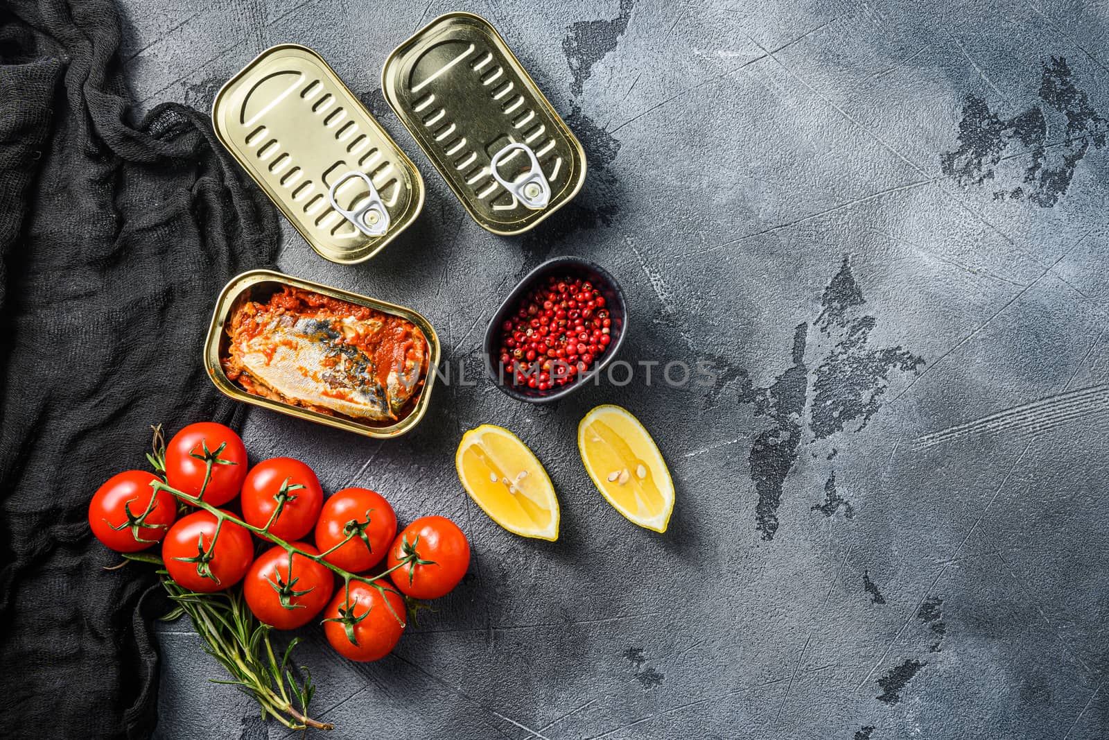 Tin can of mackerel, Scombridae opened and closed cans no label, with organic vegetables herbs and lemons top view space for text or price.
