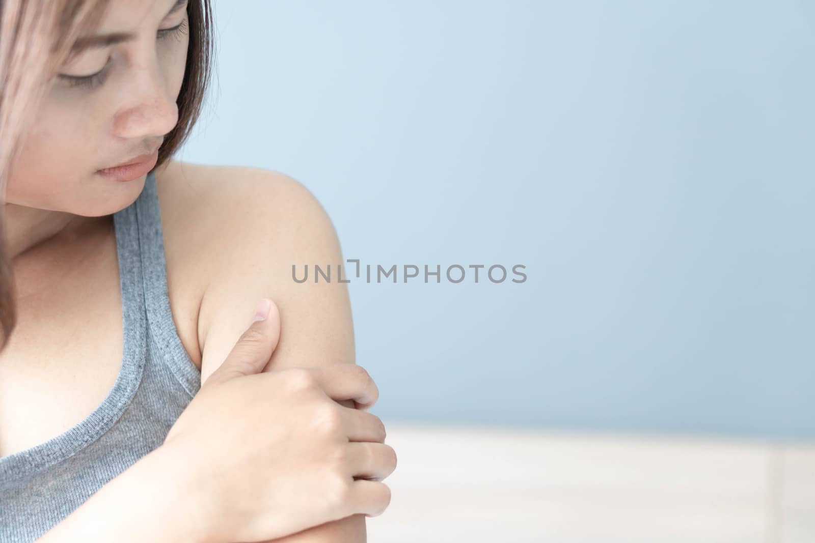 Closeup woman hand holding shoulder with pain on white background