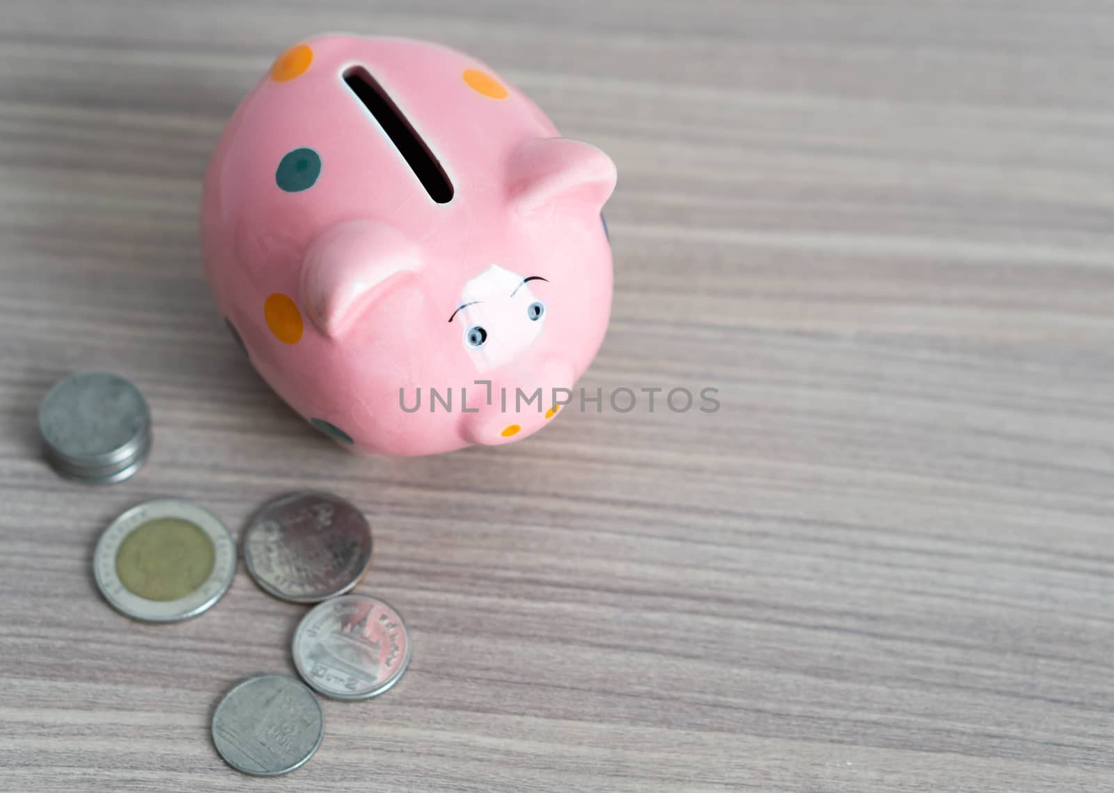 Close up pink piggy bank with coin on wood table background, Saving money concept