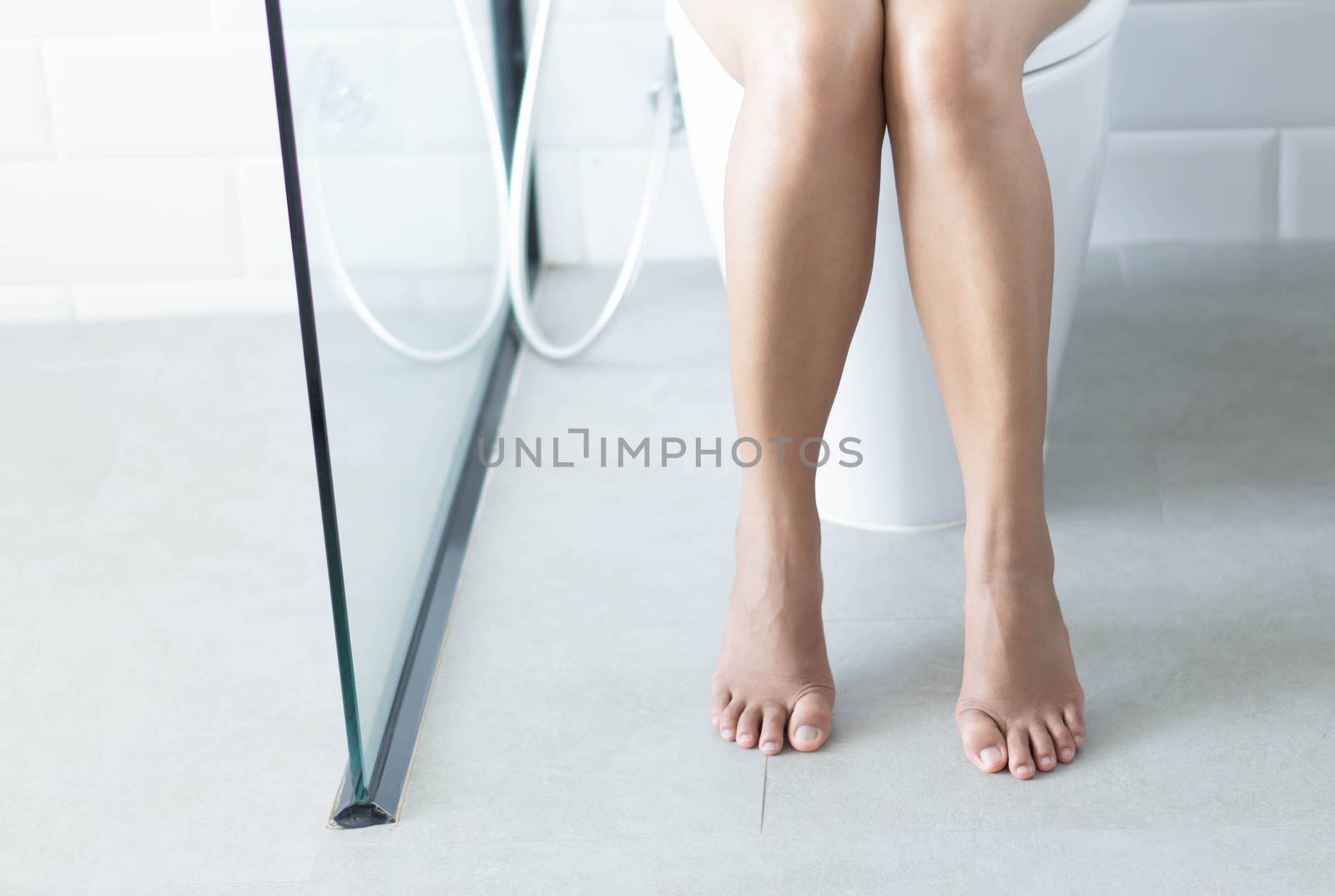Closeup woman sitting on toilet in the morning, selective focus