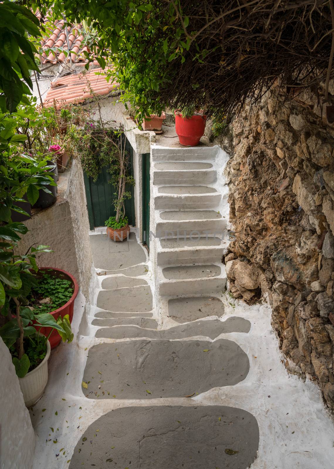 Narrow street in ancient residential district of Anafiotika in Athens Greece by steheap