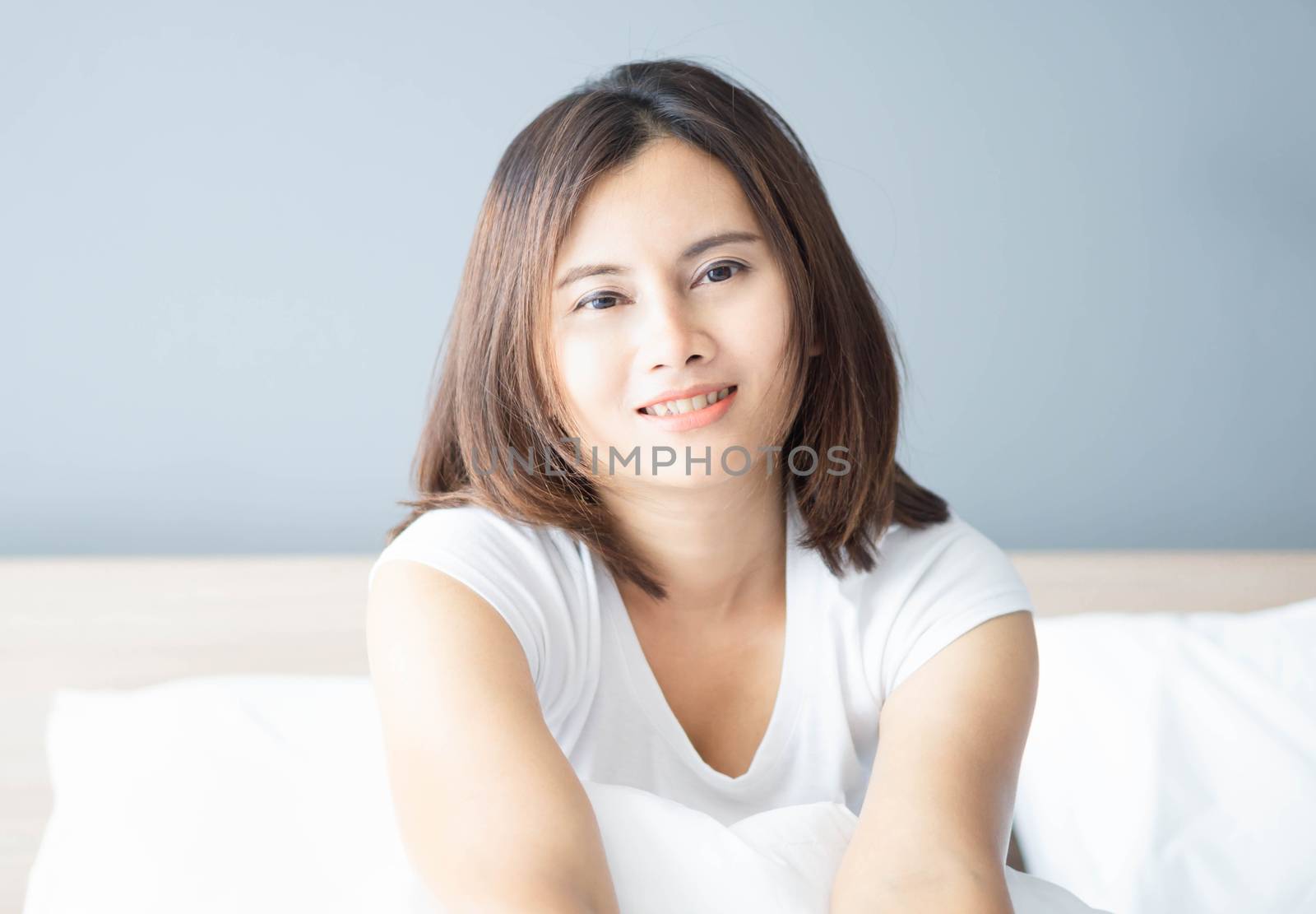 Close up asian woman smiling with happy face lying on white bed by pt.pongsak@gmail.com