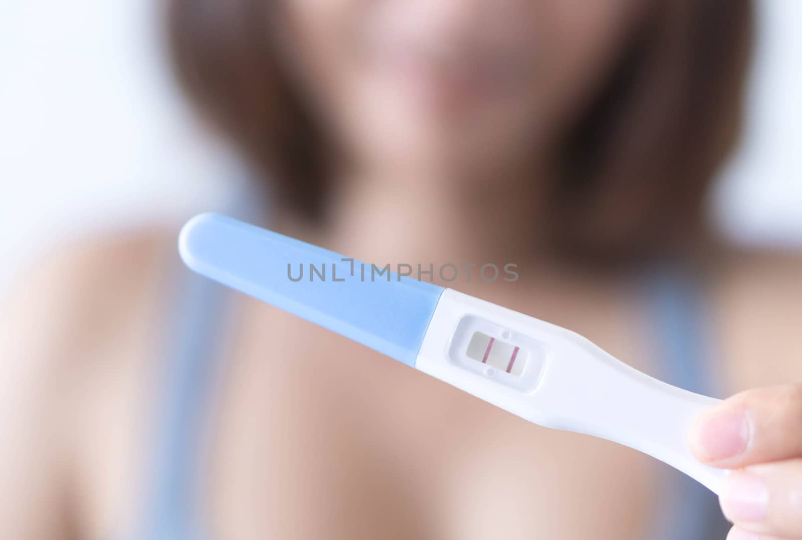 Closeup woman hand holding pregnancy test with happy moment, health care concept, selective focus