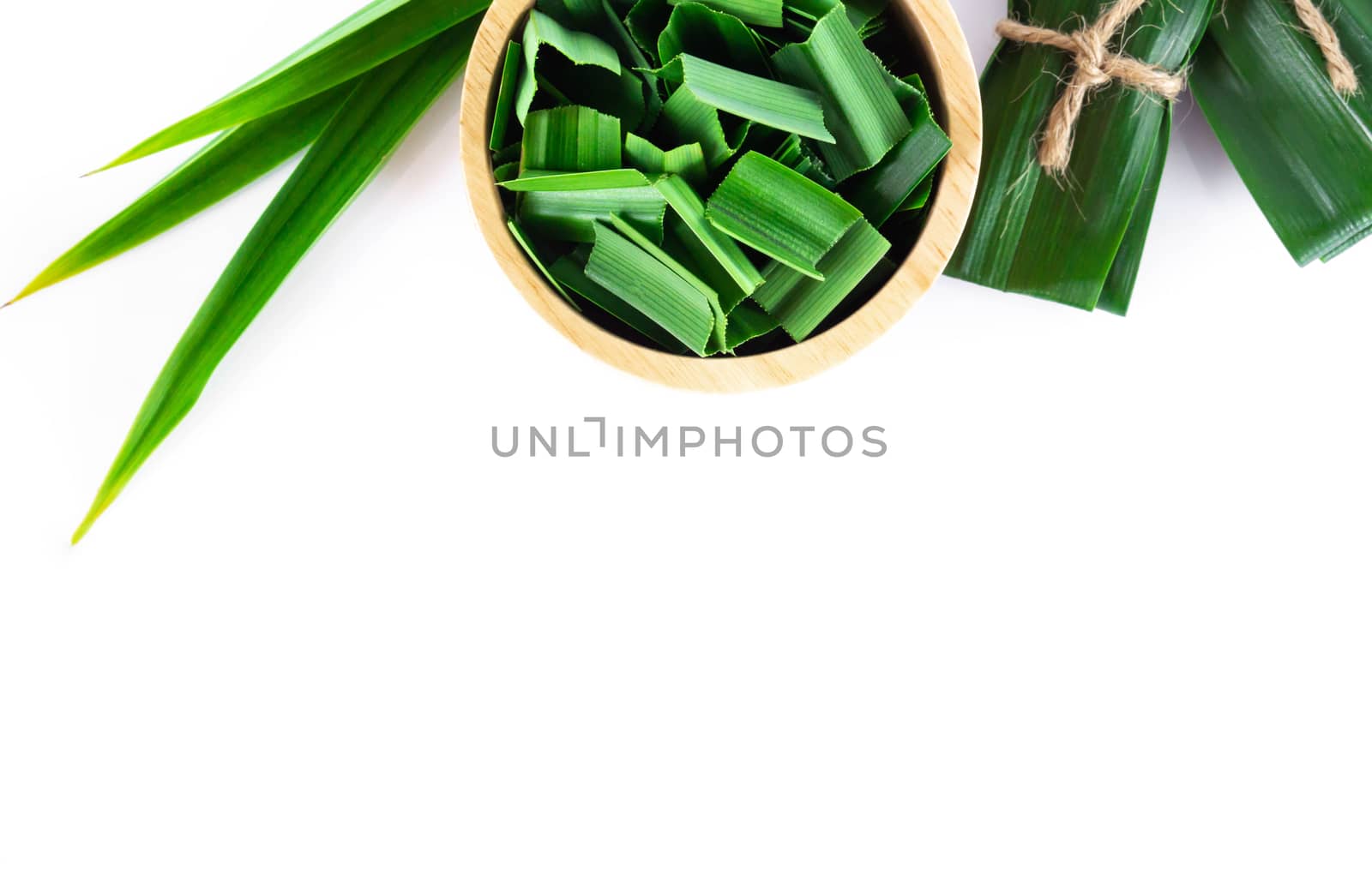 Closeup fresh green pandan in wood bowl with copy space on white background, herb and medical concept