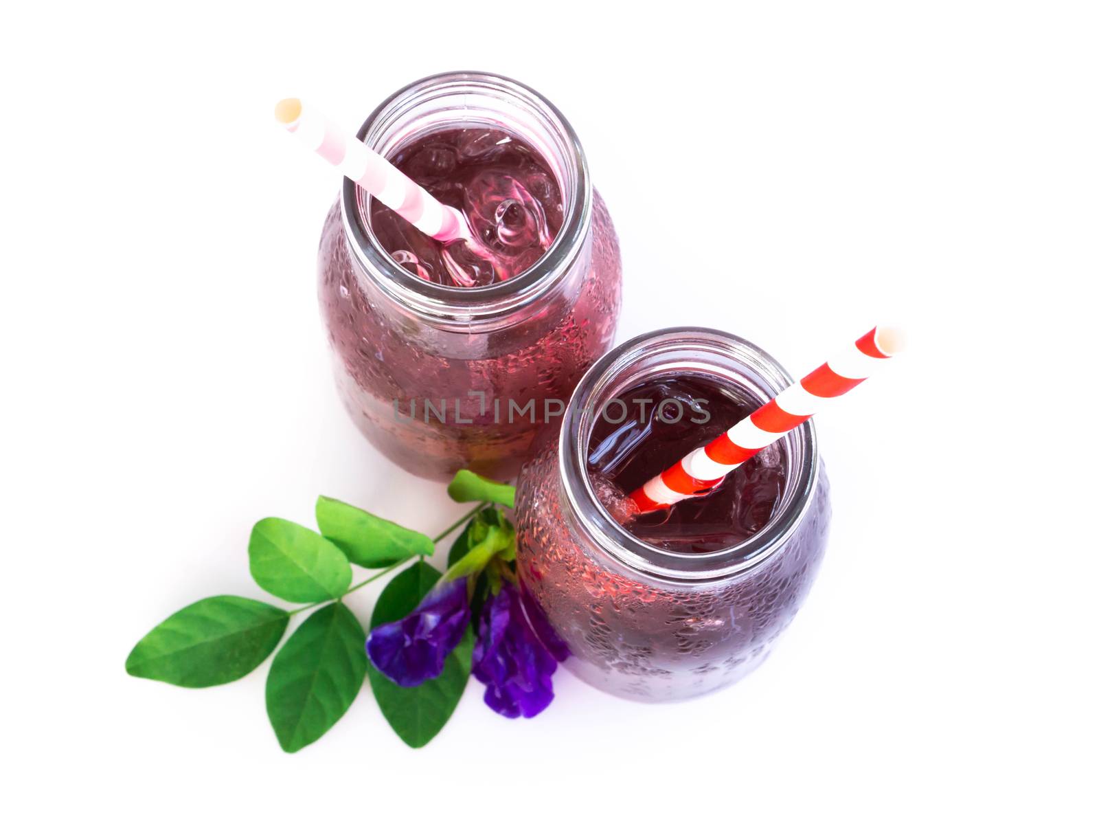 Butterfly pea juce in grass bottle with leaf and flower on white background, herb dink for healthy concept