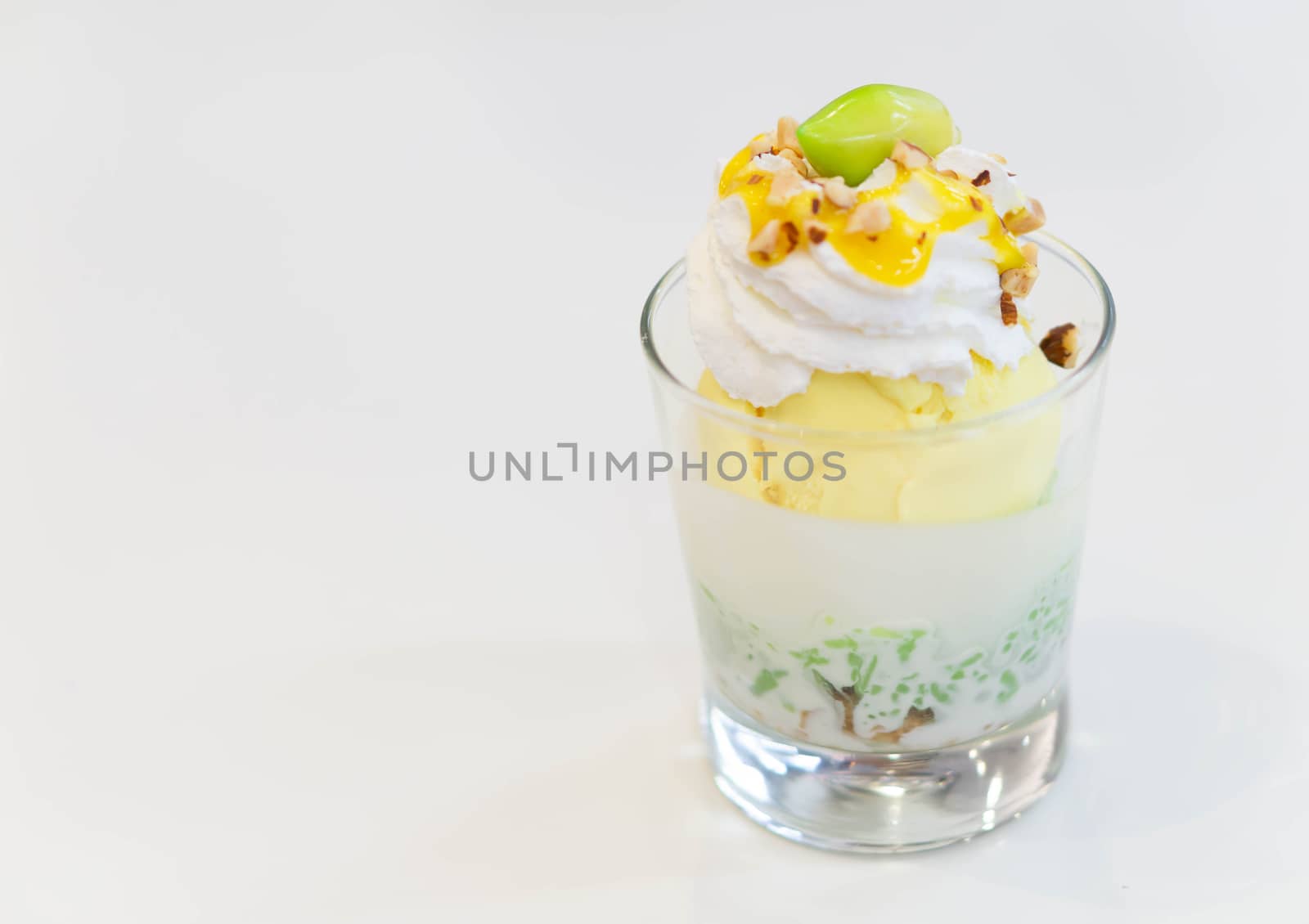 Glass of mango ice cream with wipped on white background, copy space