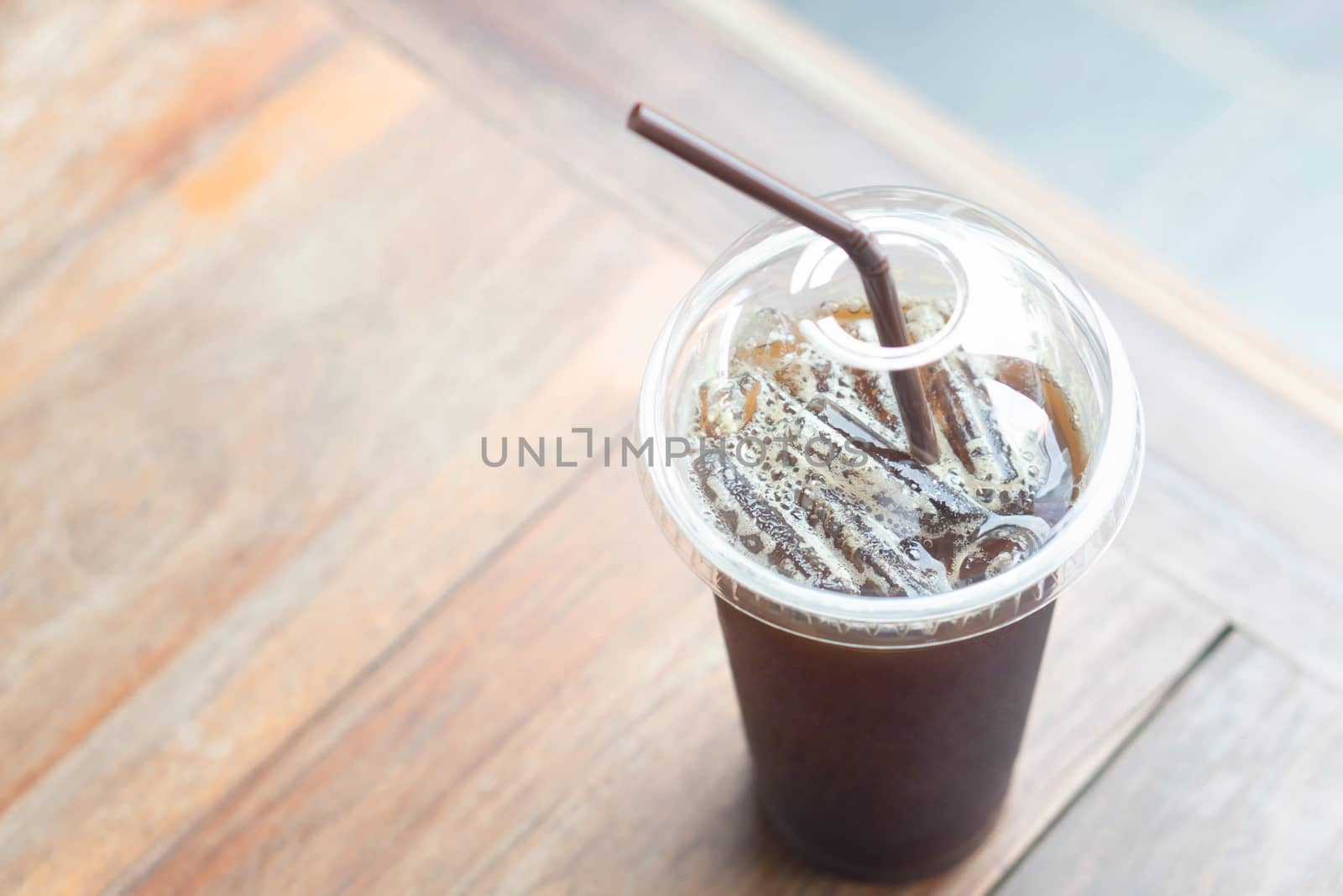 Close up ice of americano on wood table background in coffee shop