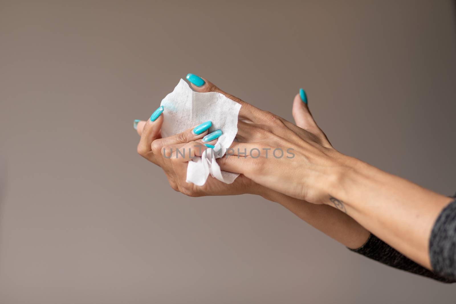 Old woman gently cleaning hands with wet wipes, white