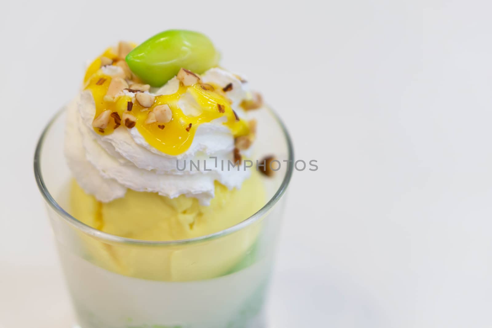 Glass of mango ice cream with wipped on white background, copy space