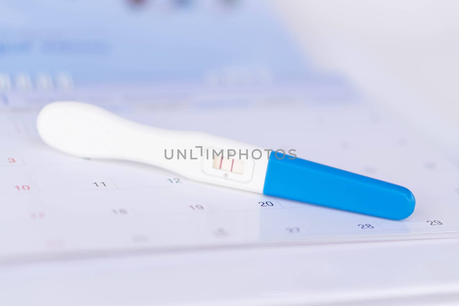 Closeup pregnancy test on calendar background, health care concept, selective focus