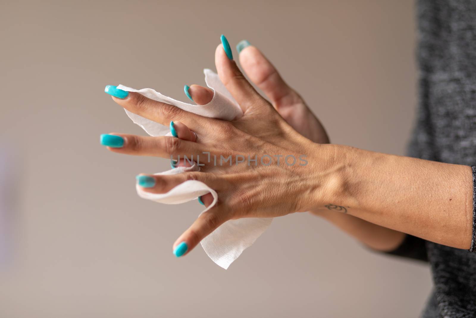 Old woman gently cleaning hands with wet wipes by adamr