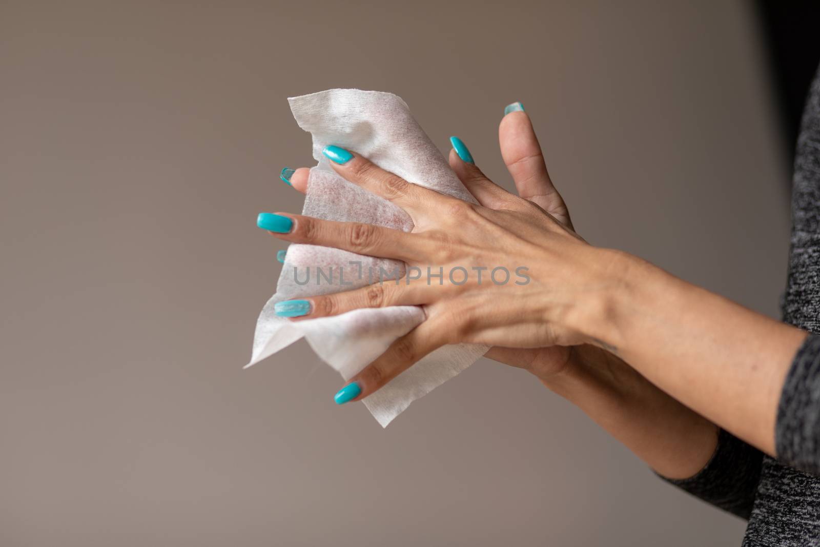 Old woman gently cleaning hands with wet wipes, white