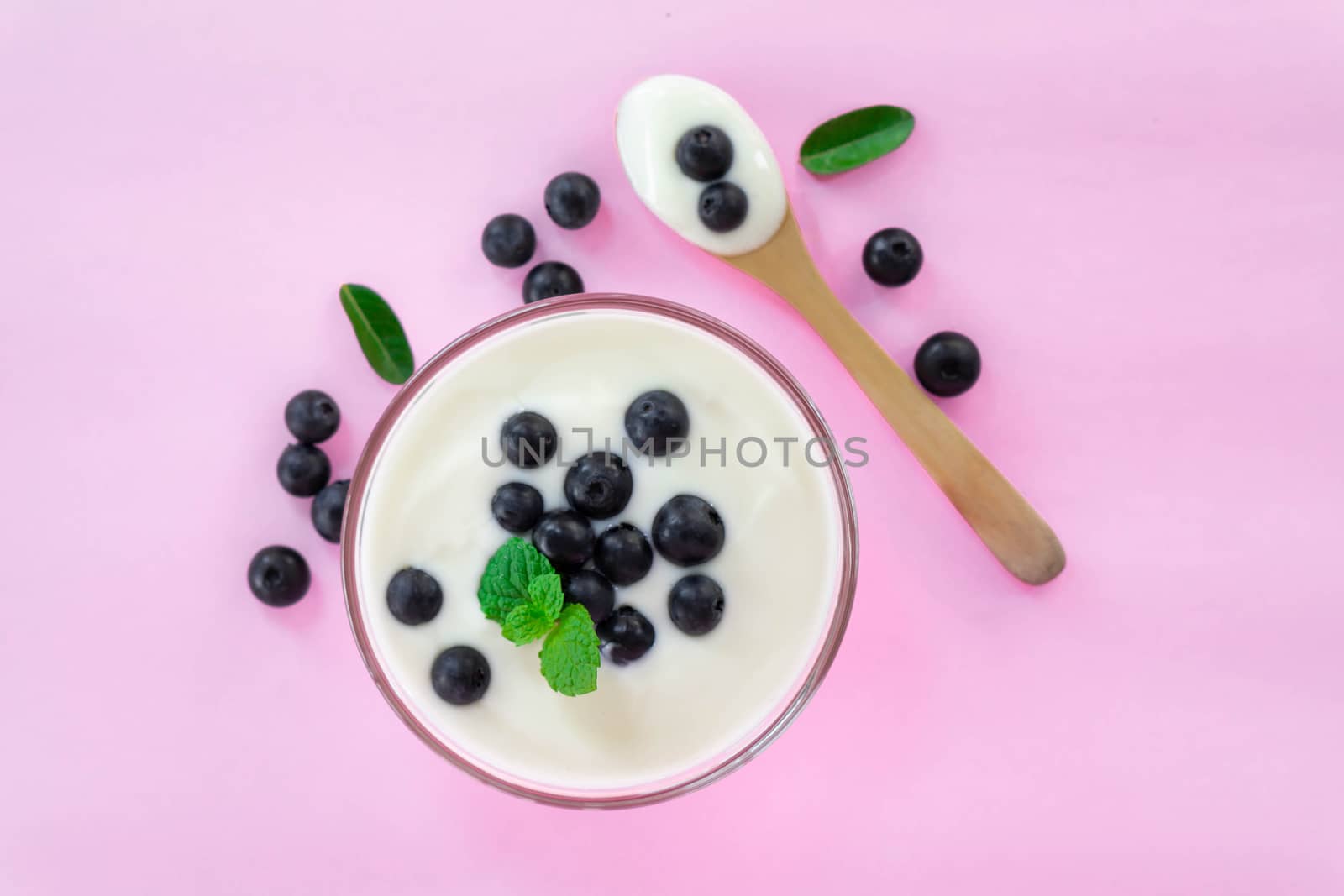 Close up yogurt with fresh blueberries  fruit in glass bowl  on pink background