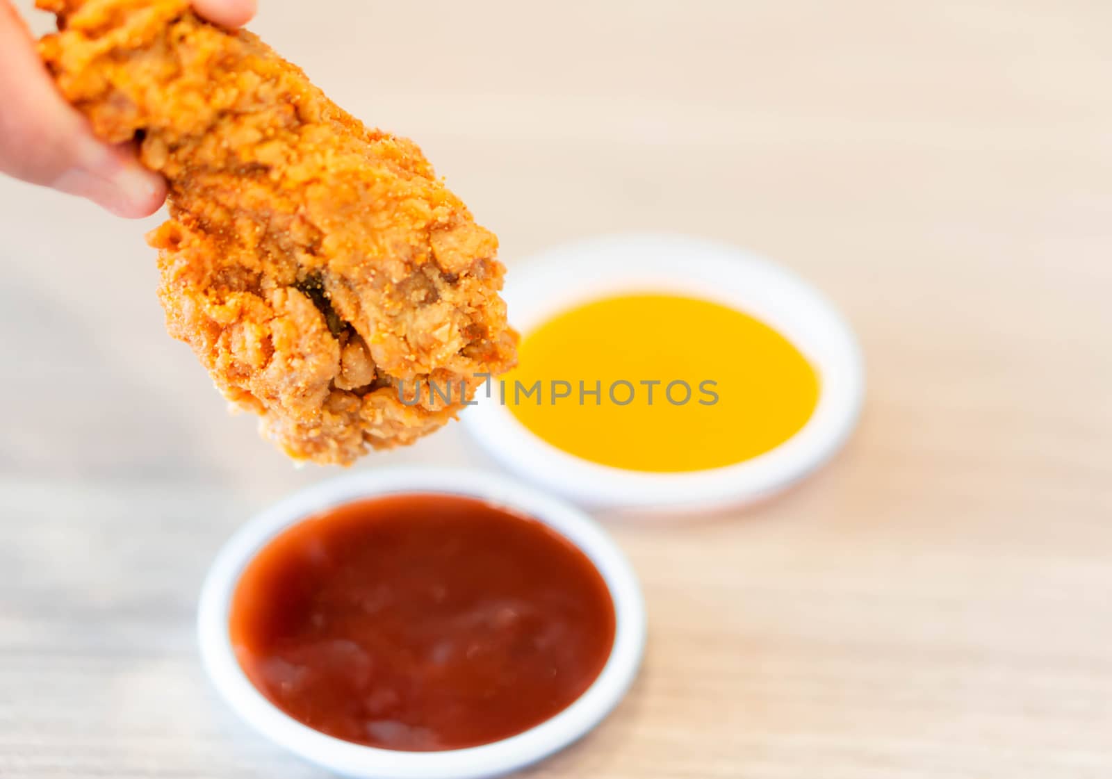 Close up fried chicken legs with sauce on wood table