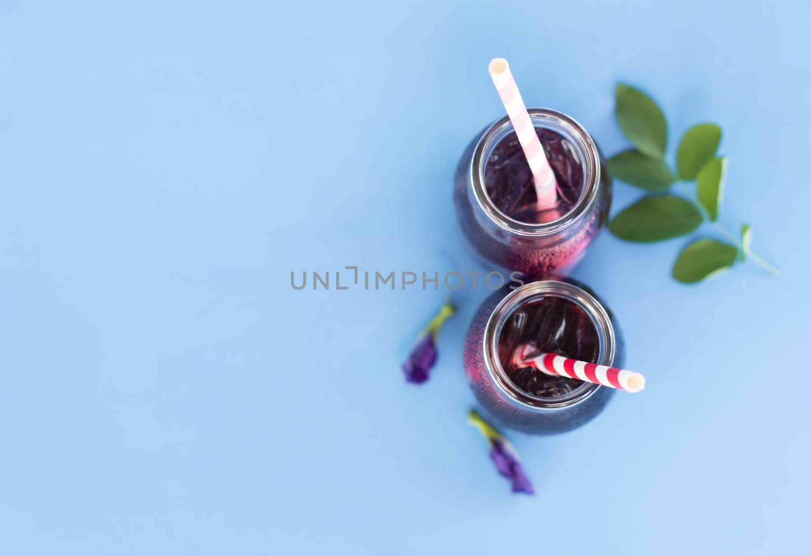 Butterfly pea juce in grass bottle with leaf and flower on light by pt.pongsak@gmail.com