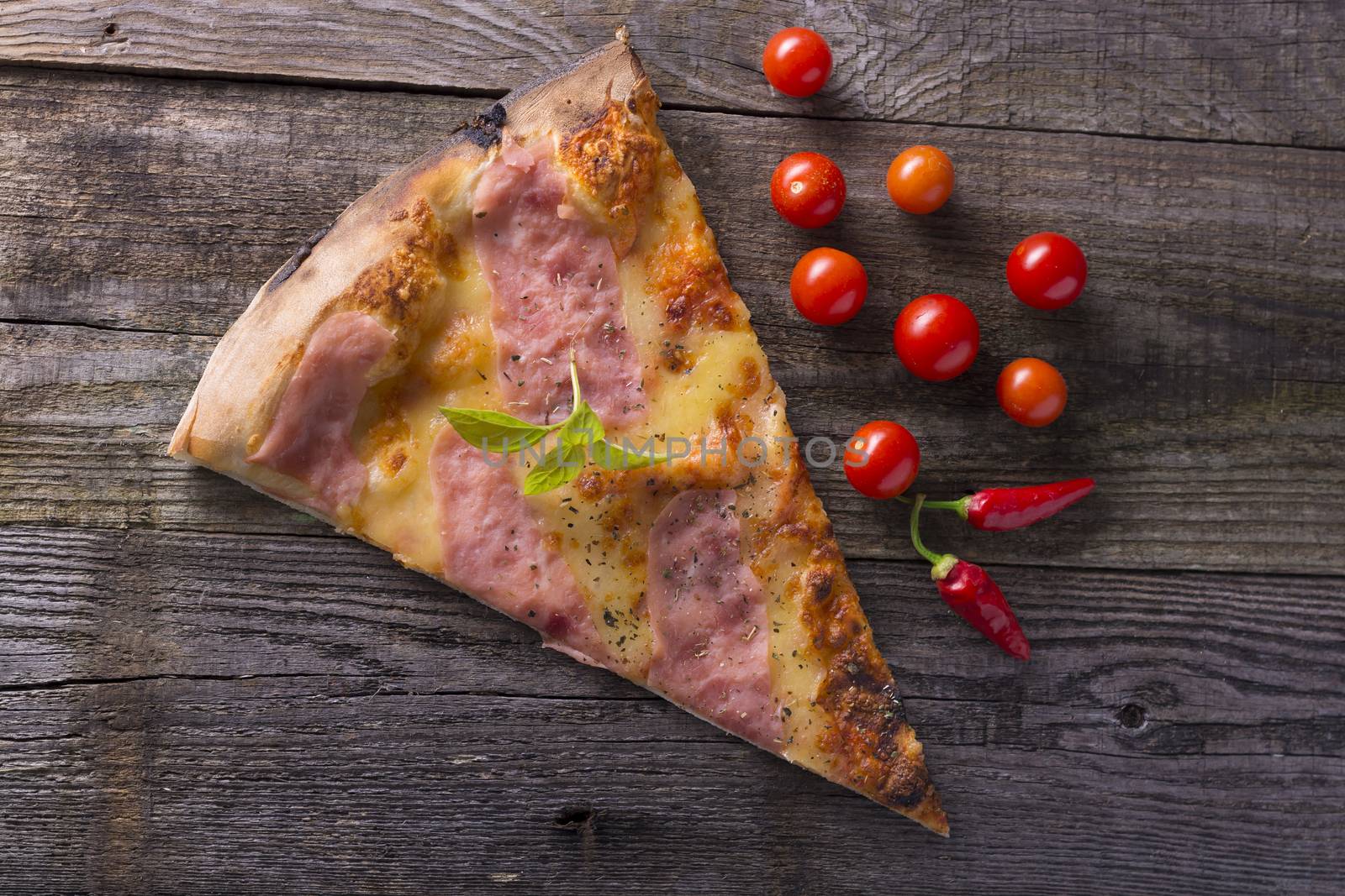 Italian food - pizza on wooden table. Cherry tomato and hot peppers