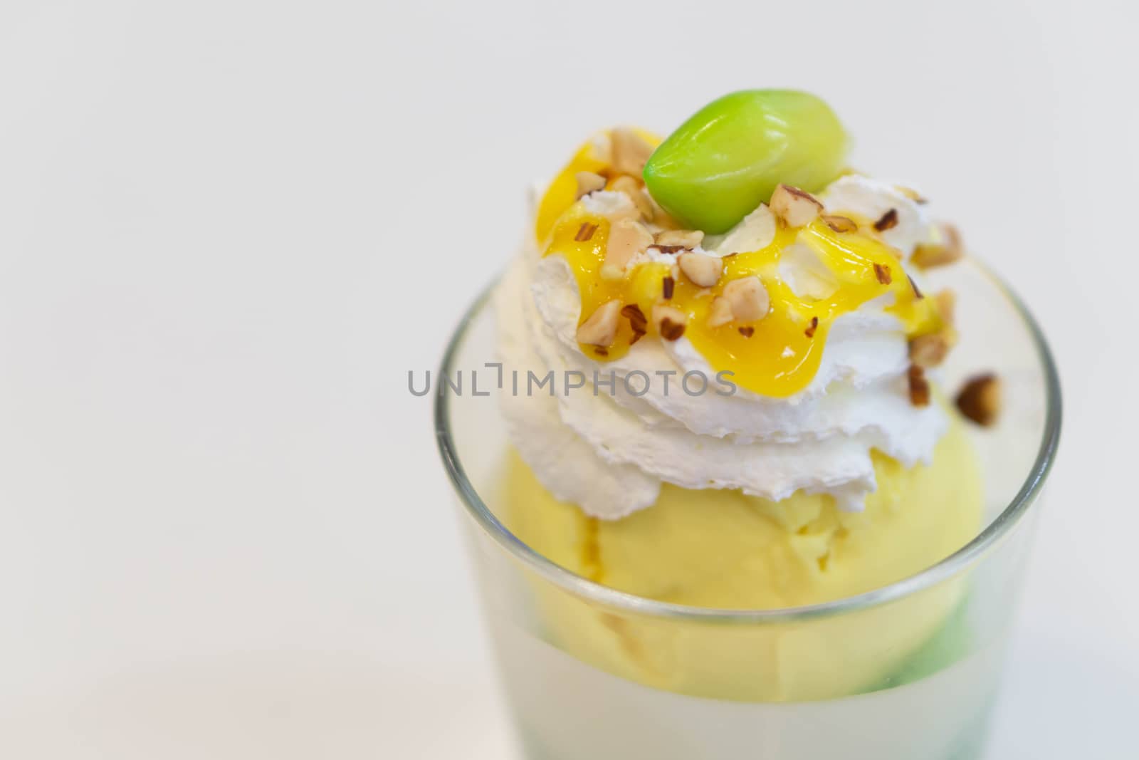 Glass of mango ice cream with wipped on white background, copy space