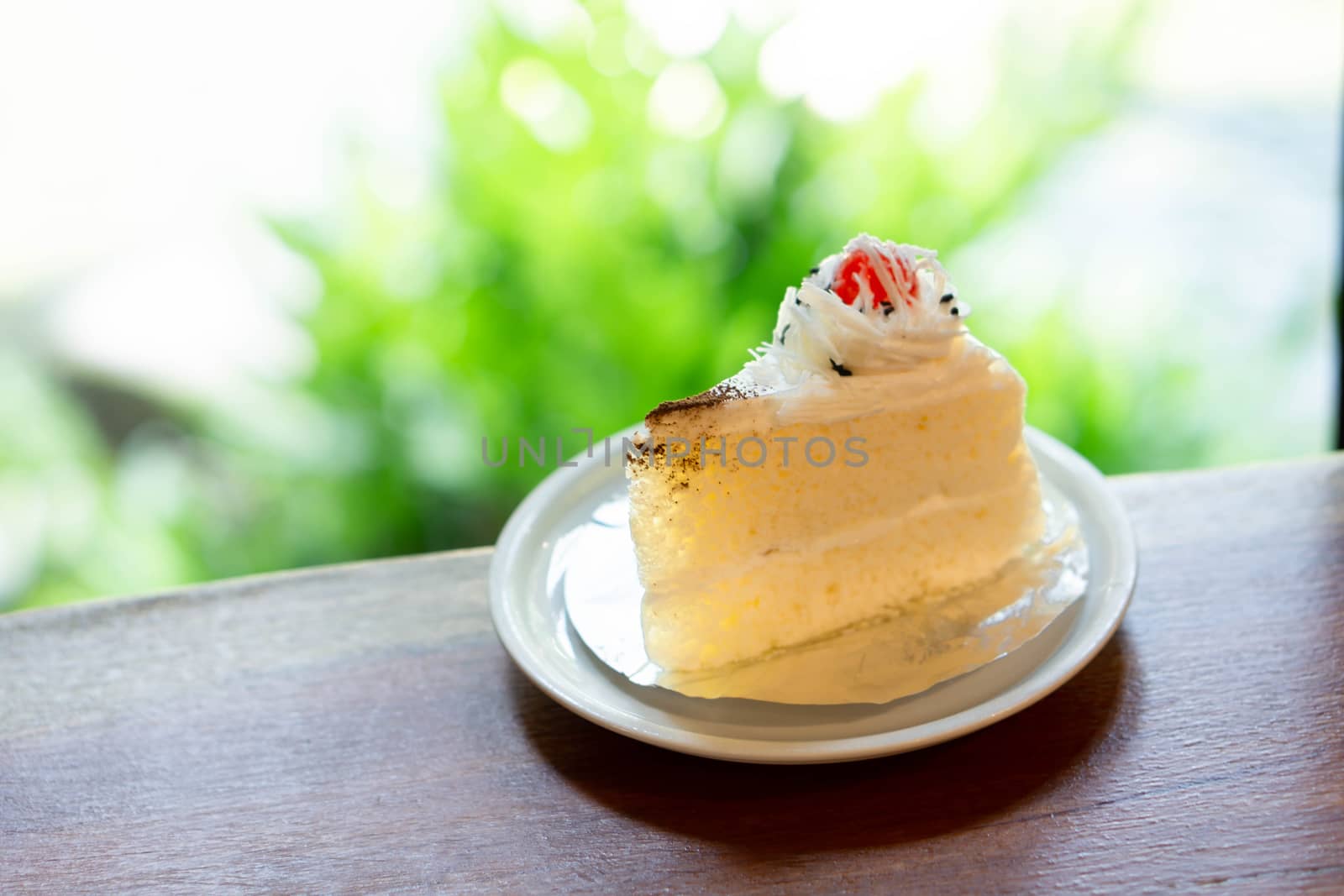 Closeup milk cake on wood table with green nature background, selective focus